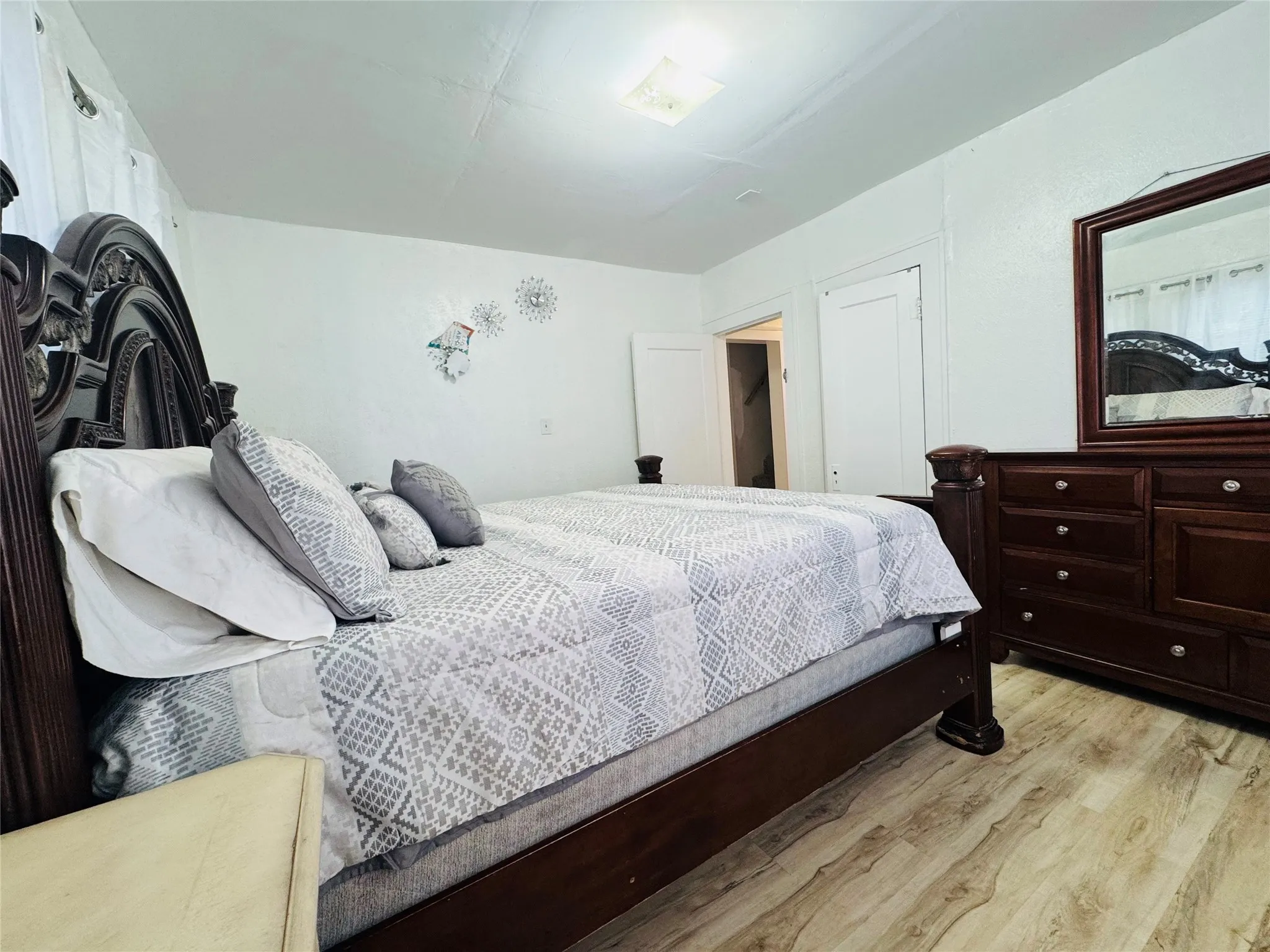 Room featuring wood-finish flooring, white walls, and a recessed ceiling light