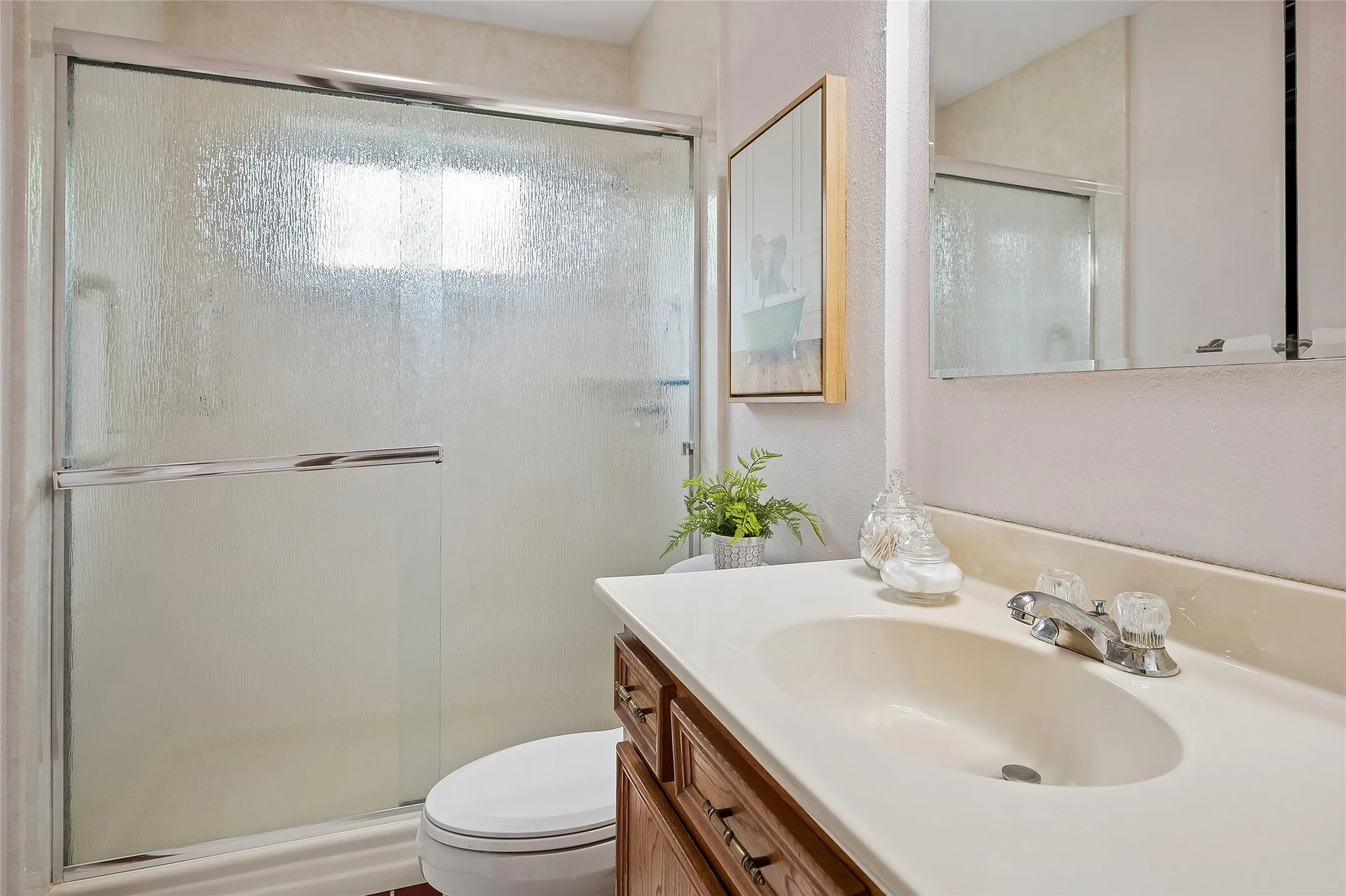 Hall bath with updated fixtures and built-in corner shower caddy.
