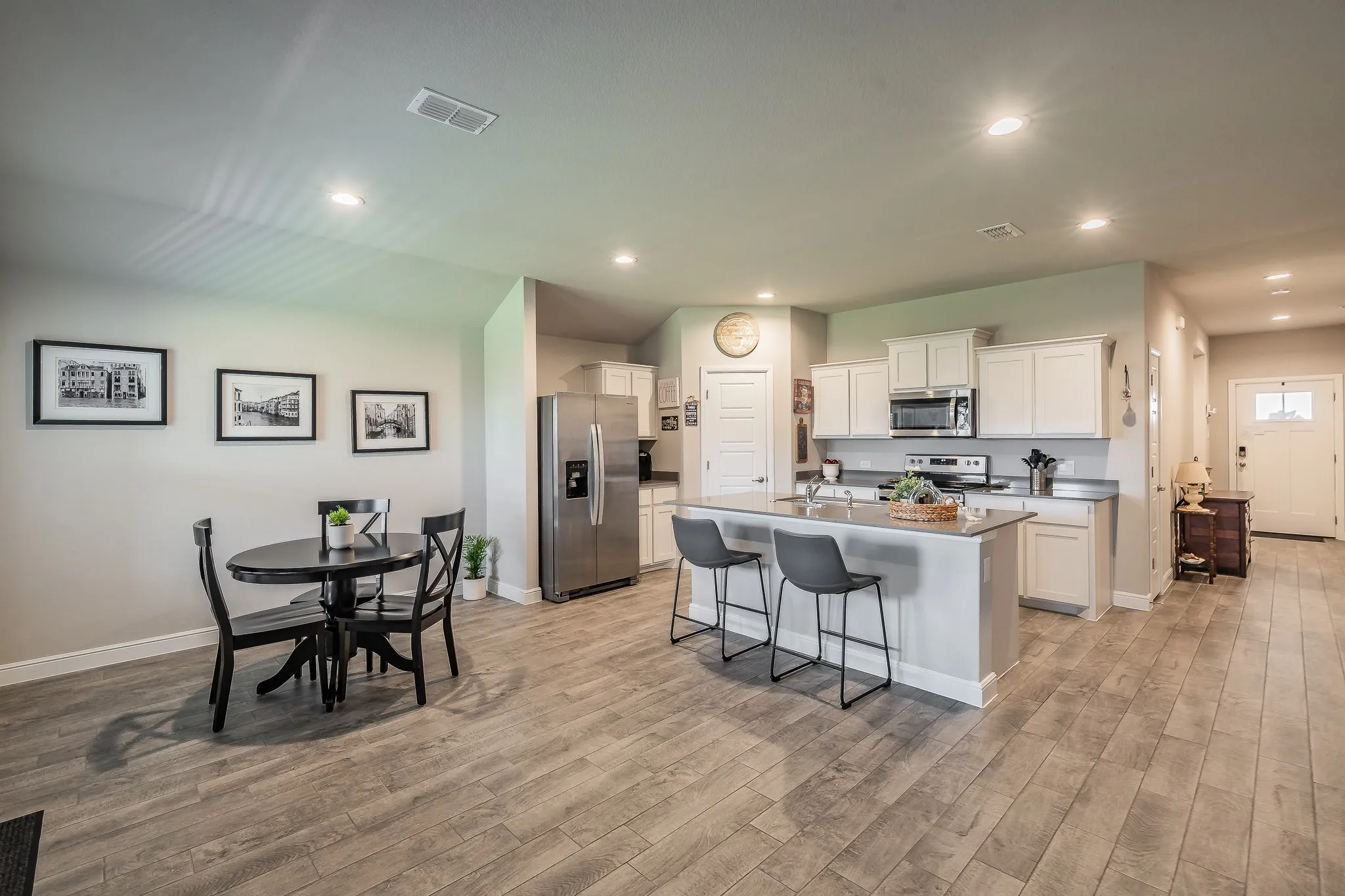 Open-concept kitchen and dining area featuring ceramic plank tile flooring throughout