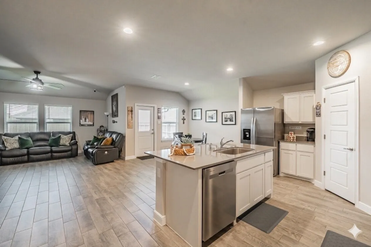 Open-concept living space featuring wood-finish flooring, recessed lighting, and a vaulted ceiling