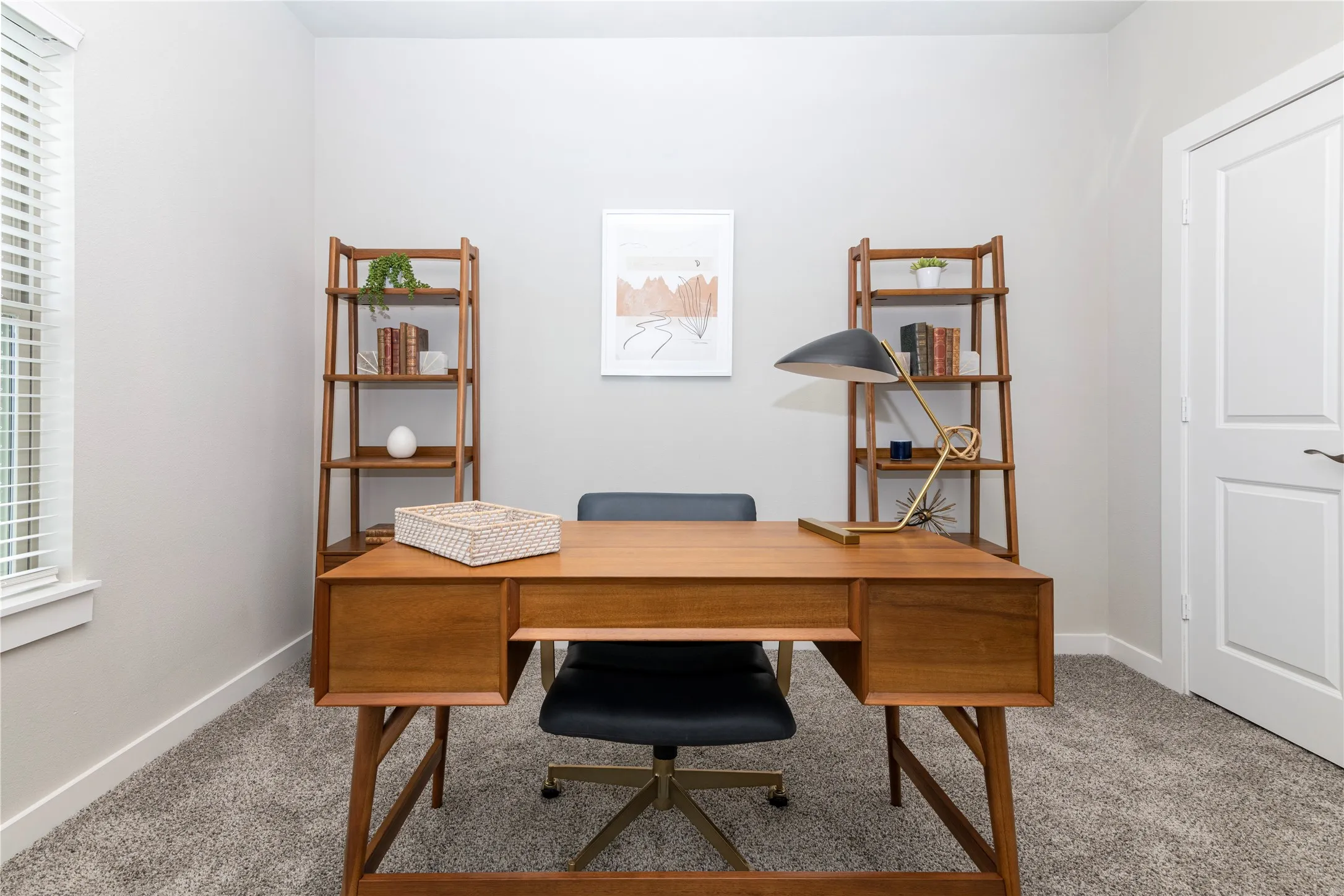 Room featuring wall-to-wall carpeting, a window with blinds, and a white paneled door