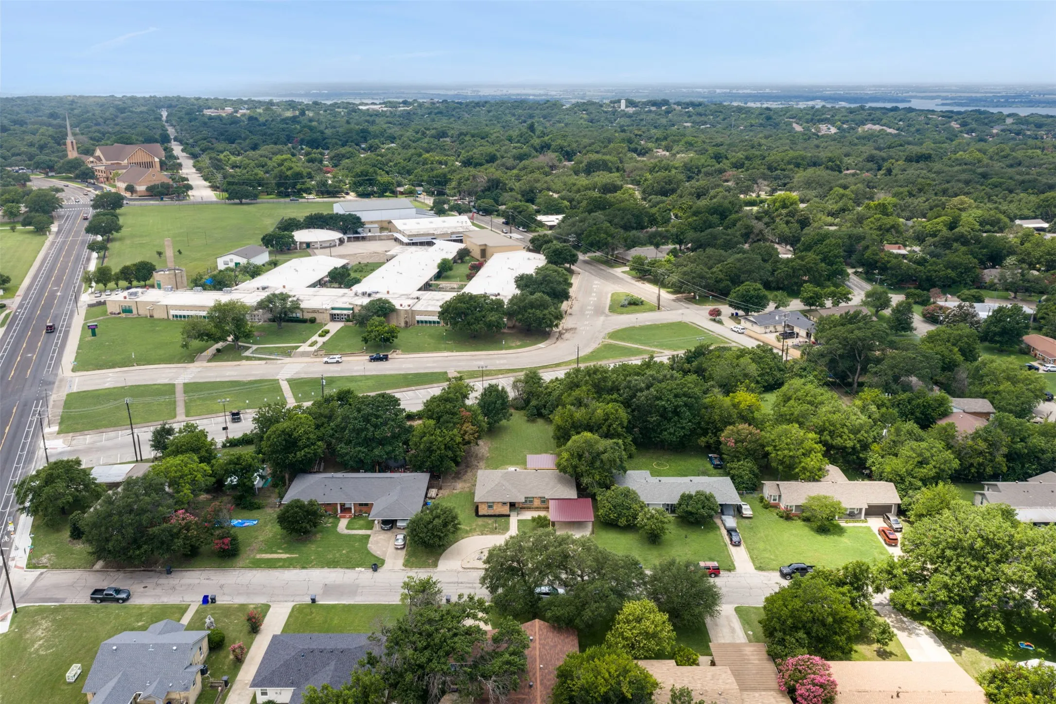 Aerial perspective showcasing a residential area with established trees and multiple single-story homes