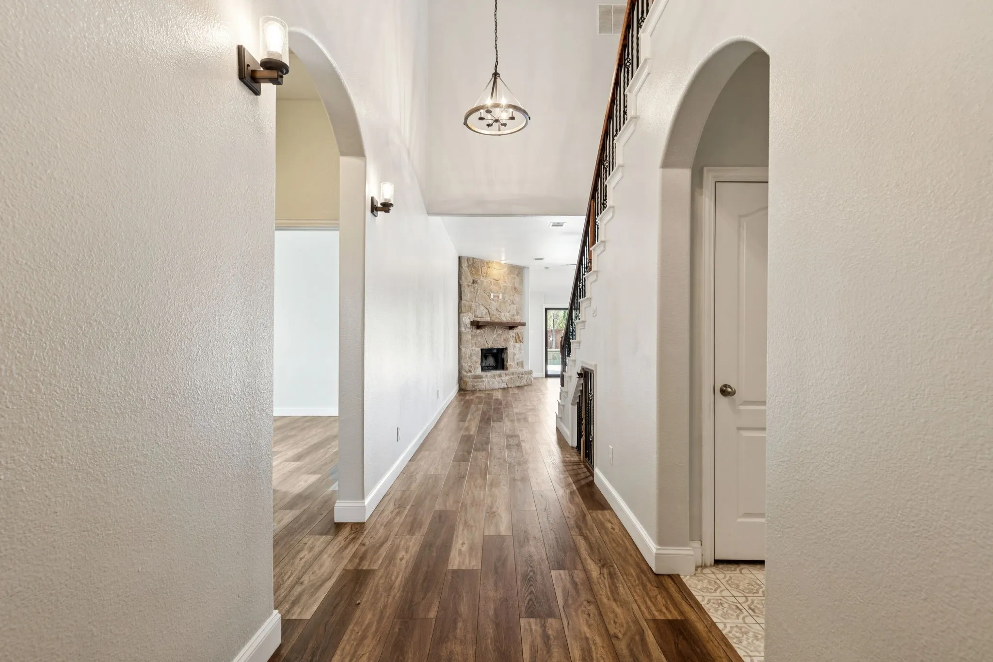 Hallway with a textured wall and dark wood-style floors