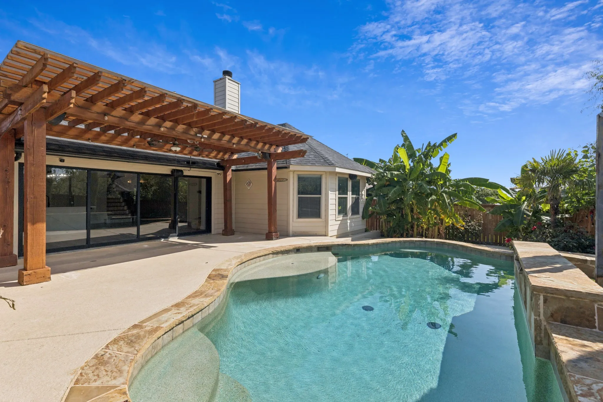 Swimming pool with a pergola and a patio