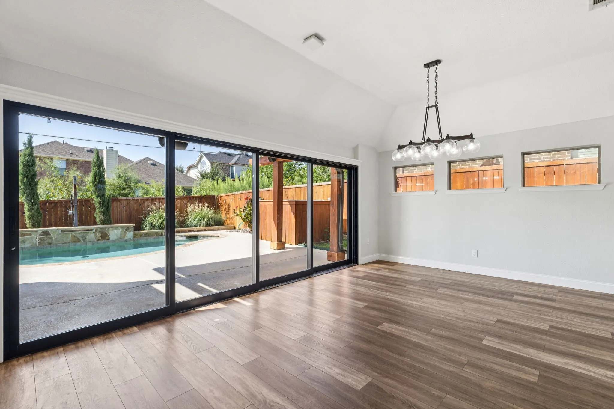 Unfurnished dining area featuring plenty of natural light, wood finished floors, and vaulted ceiling