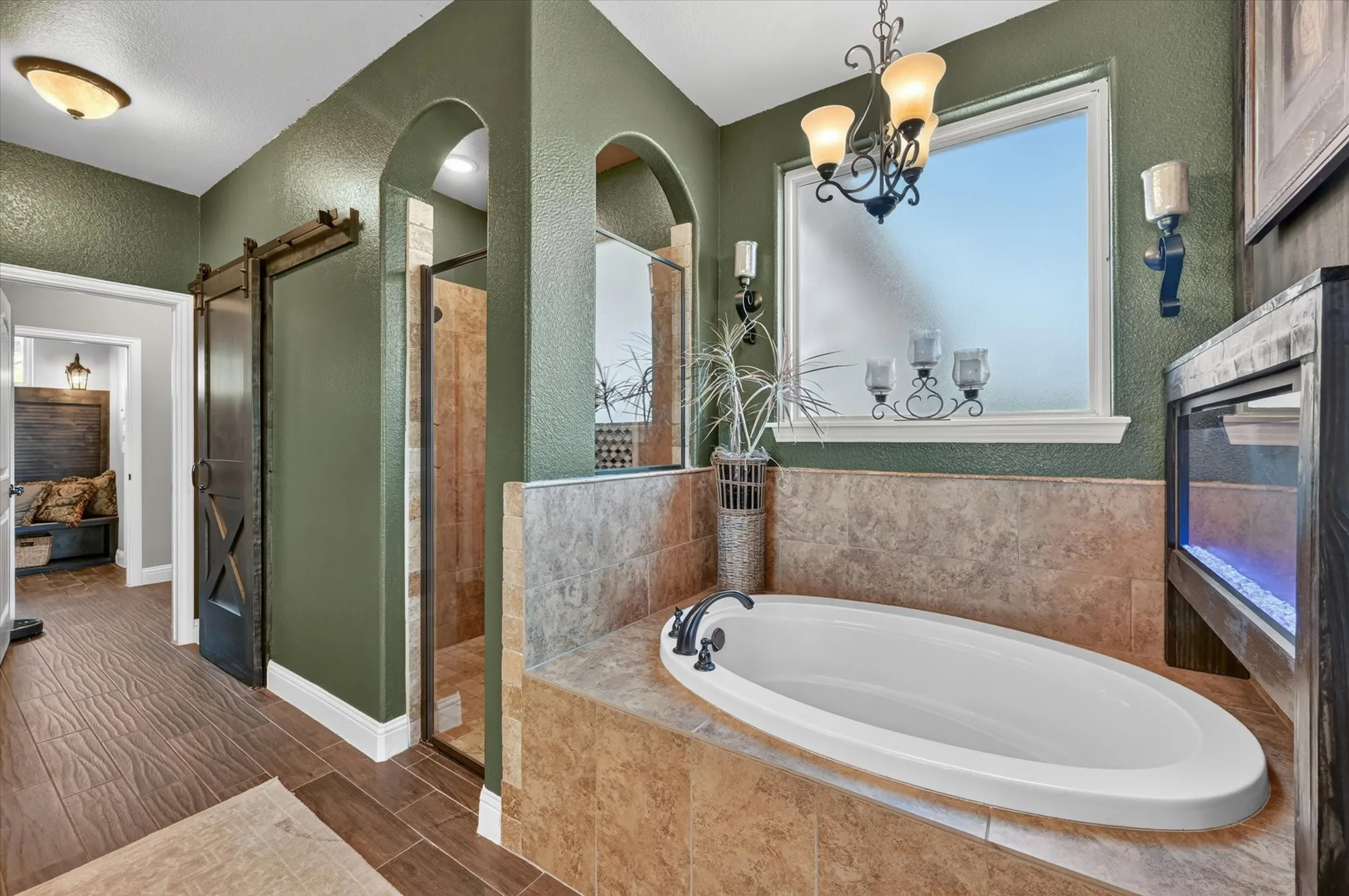 Soaking tub with bronze-finish fixtures set in a tiled surround