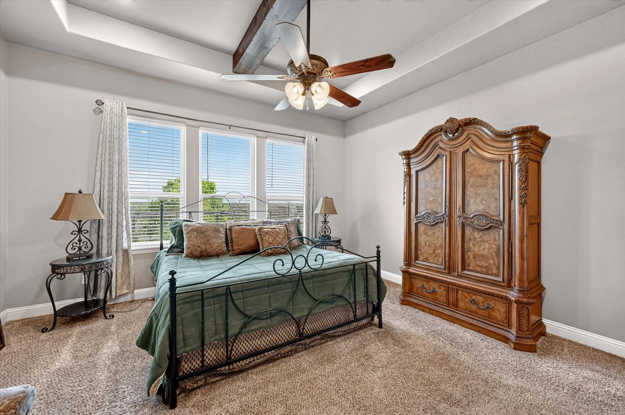 Tray ceiling with exposed wood beam and ceiling fan