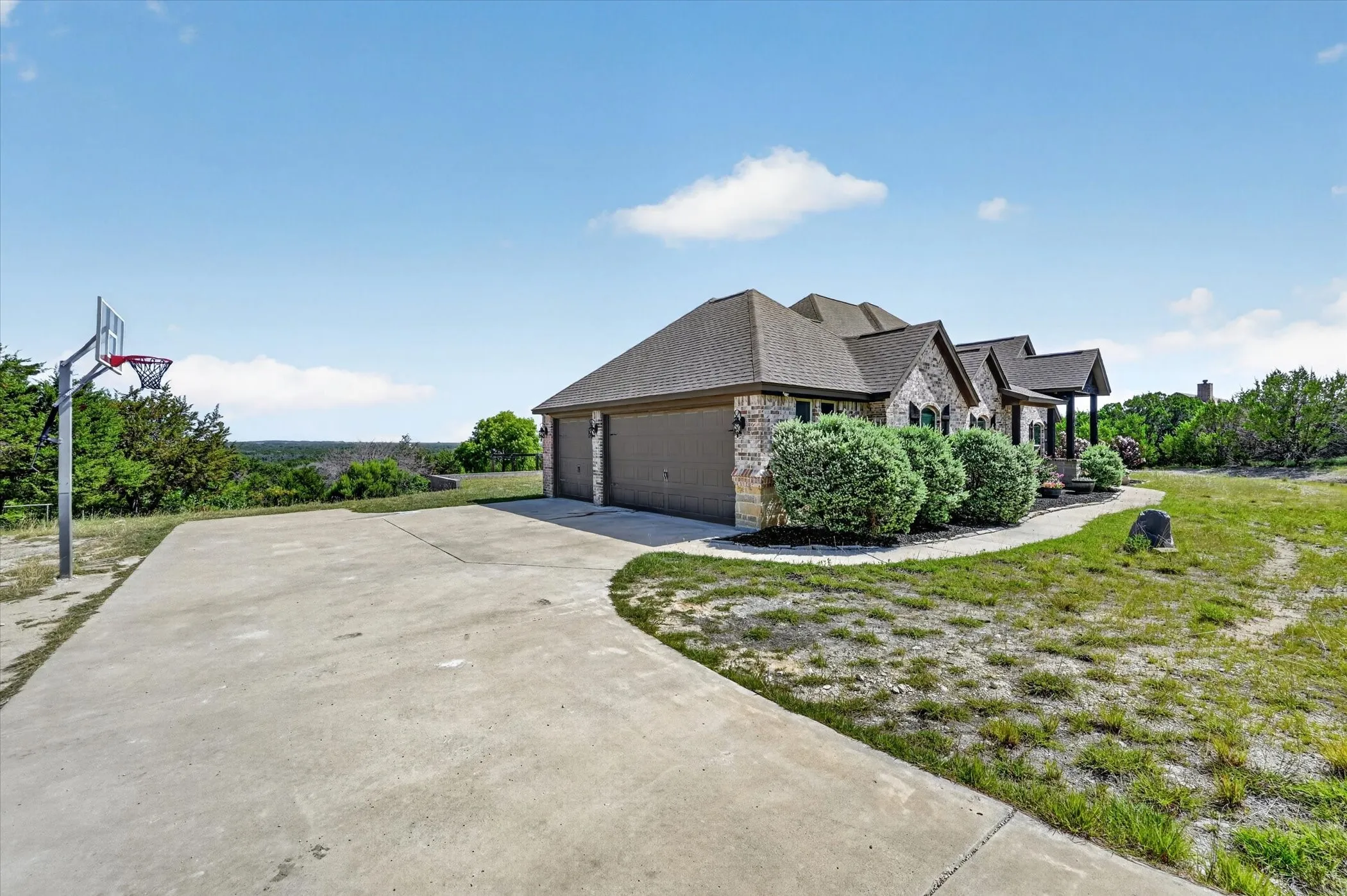 Stone exterior with a composite shingle roof and a three-car garage