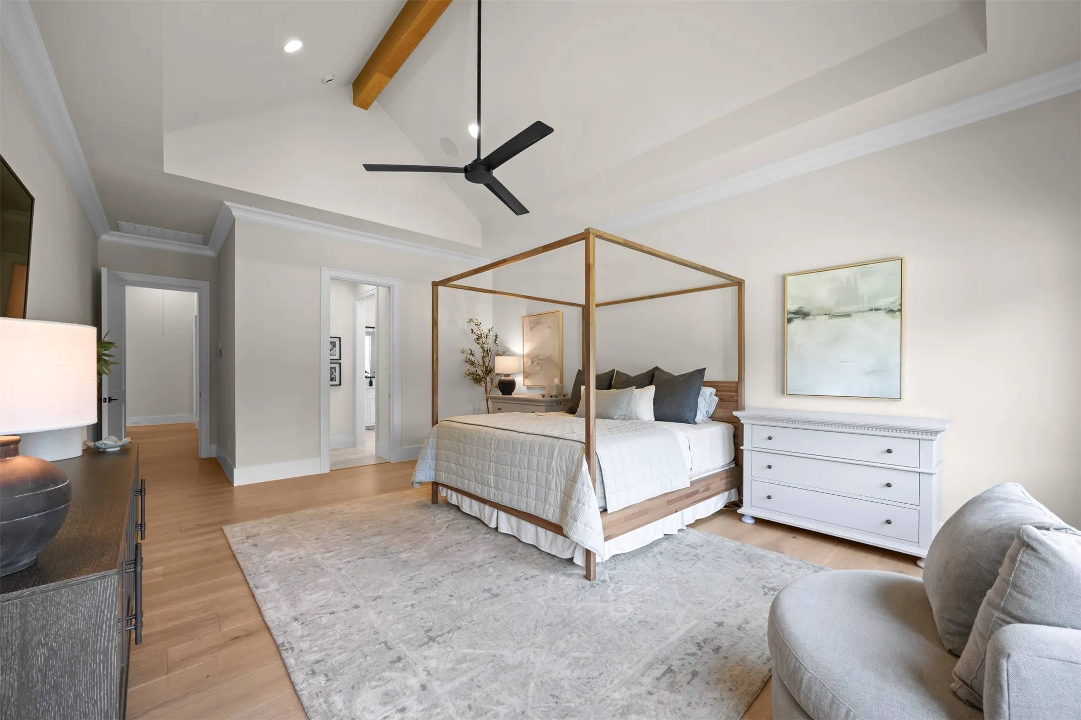 Vaulted ceiling and a wood beam are the finishing touch to this serene primary suite
