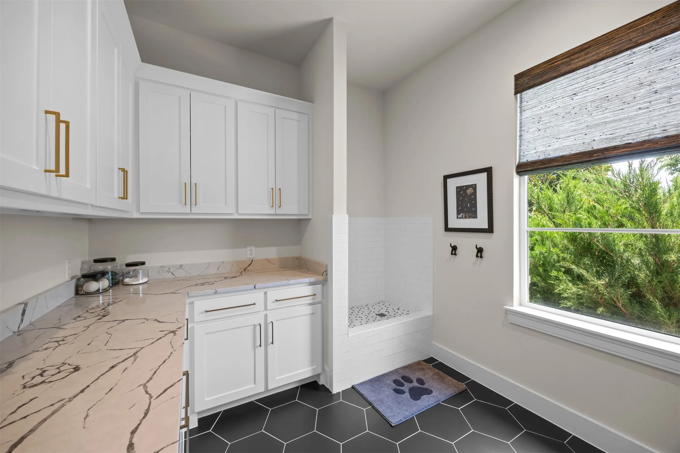 This laundry room is something special! Complete with beautiful tile, countertops & plenty of storage. And take a look at the pet washing station or whatever you need to wash! That is awesome!