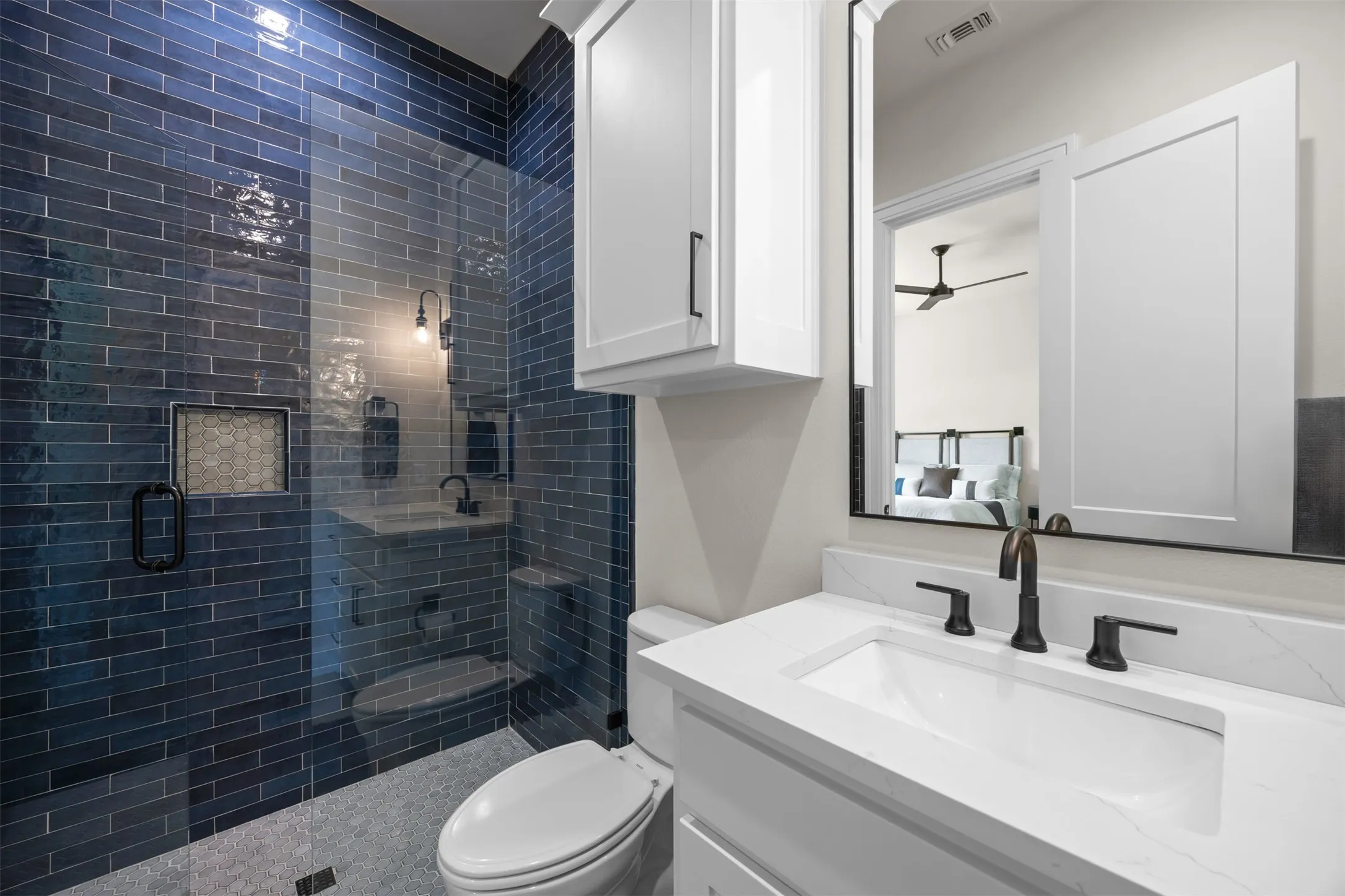 This designer ensuite bathroom makes a beautiful, bold statement with the high end tile and crisp, white surrounding details.