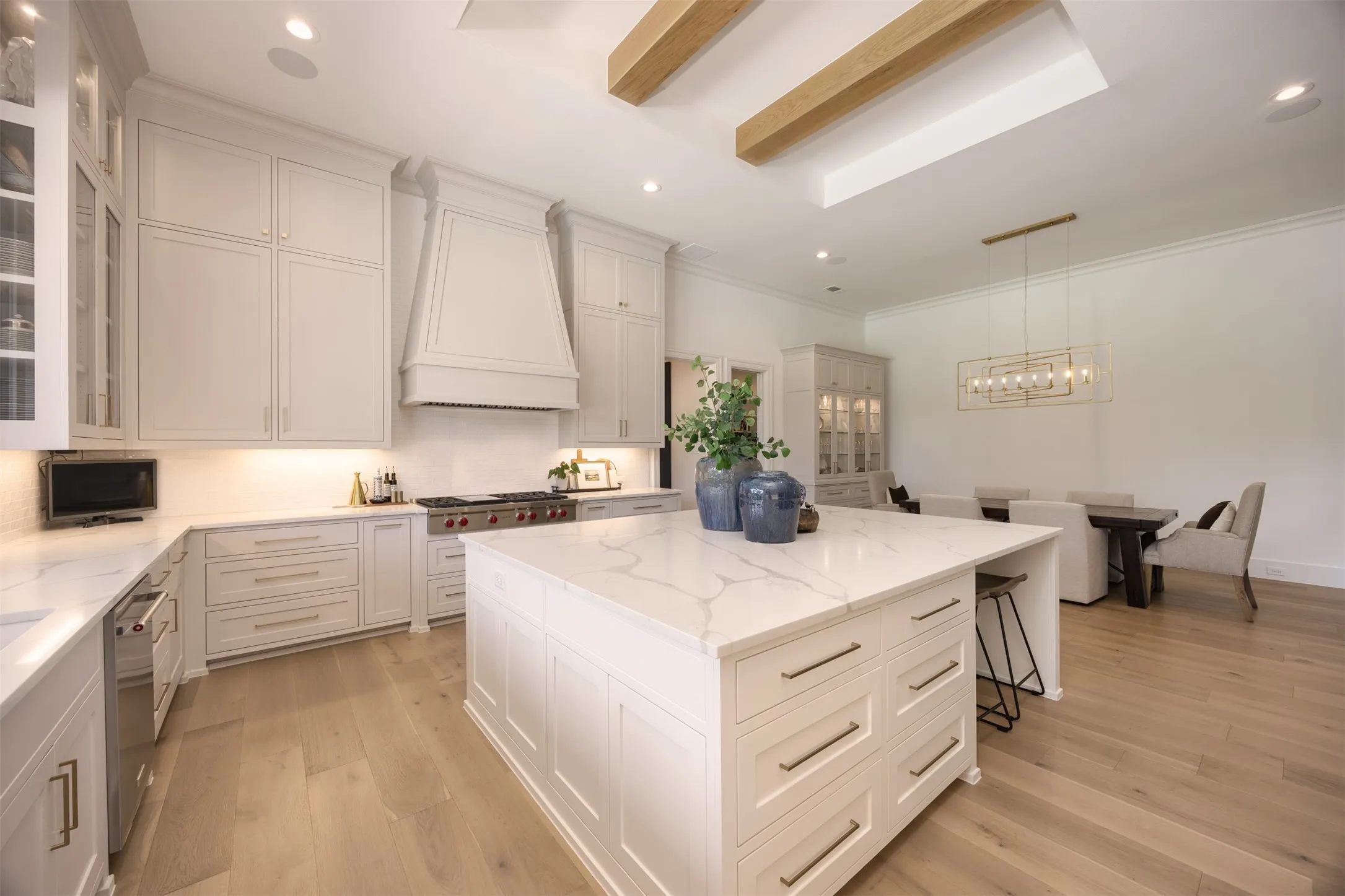 Warm wood beams, custom hardware & vent hood are the perfect finishing touches in this incredible space