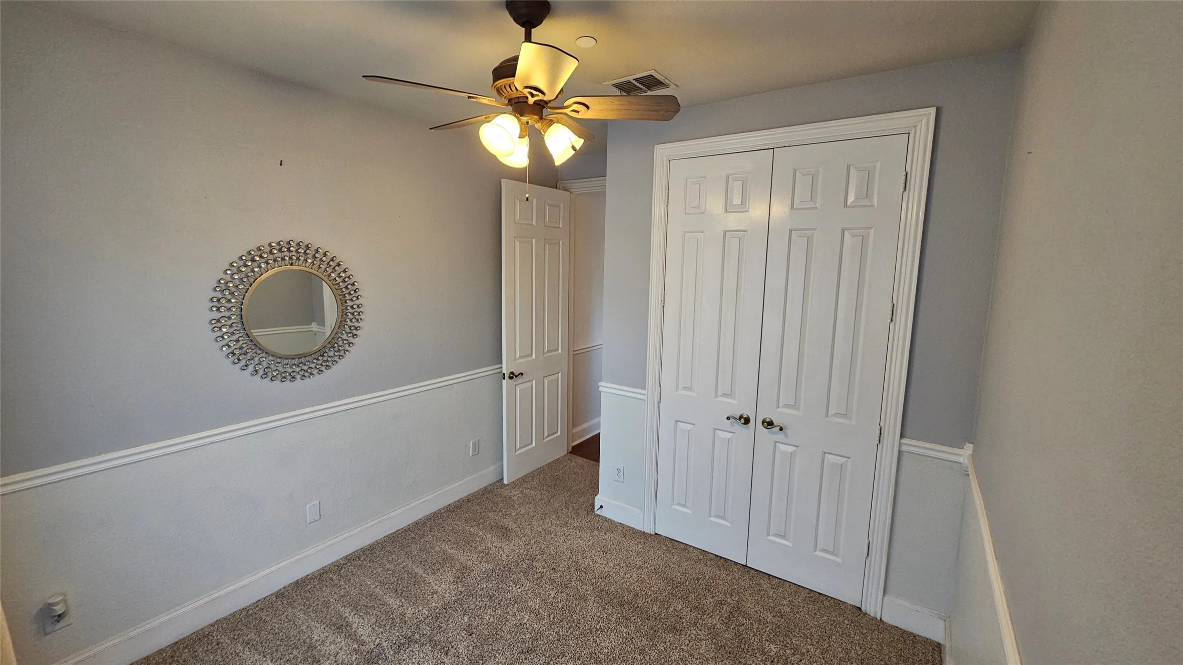 Neutral-toned carpeting paired with light grey walls and white wainscoting