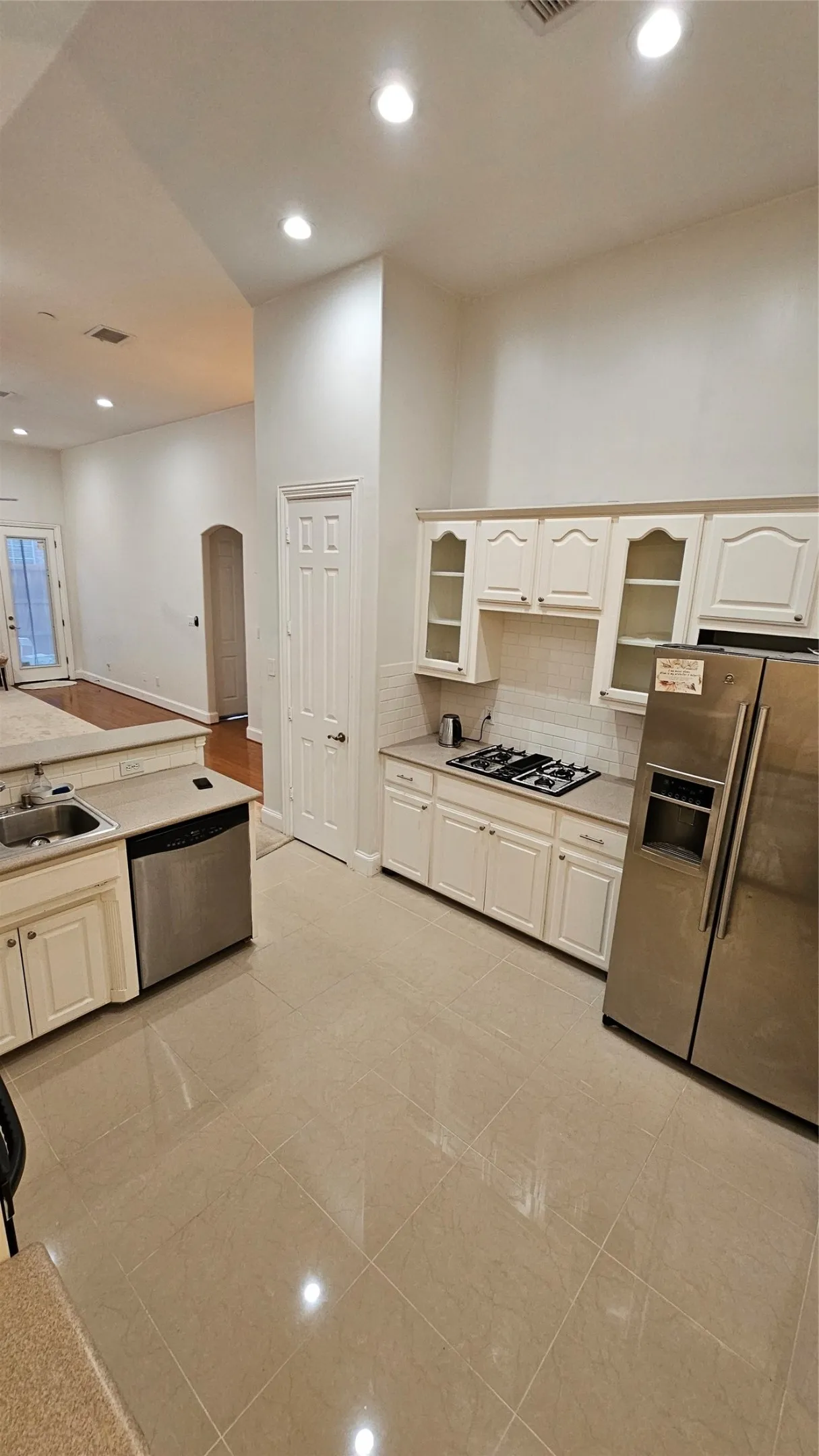 Kitchen featuring light-toned tile flooring, recessed lighting, white cabinetry, a built-in gas cooktop, and stainless steel appliances