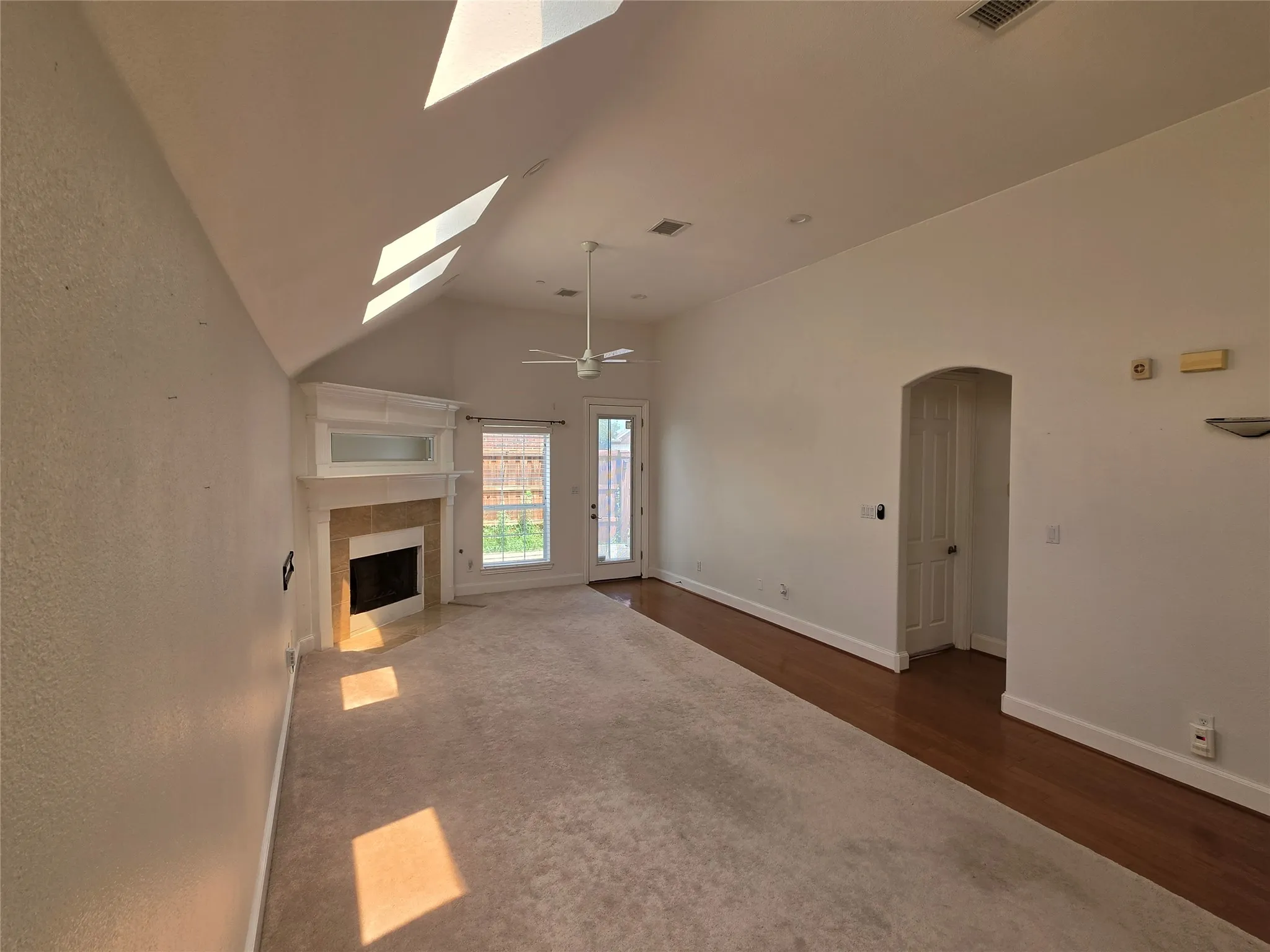 Living area with vaulted ceilings and a white ceiling fan