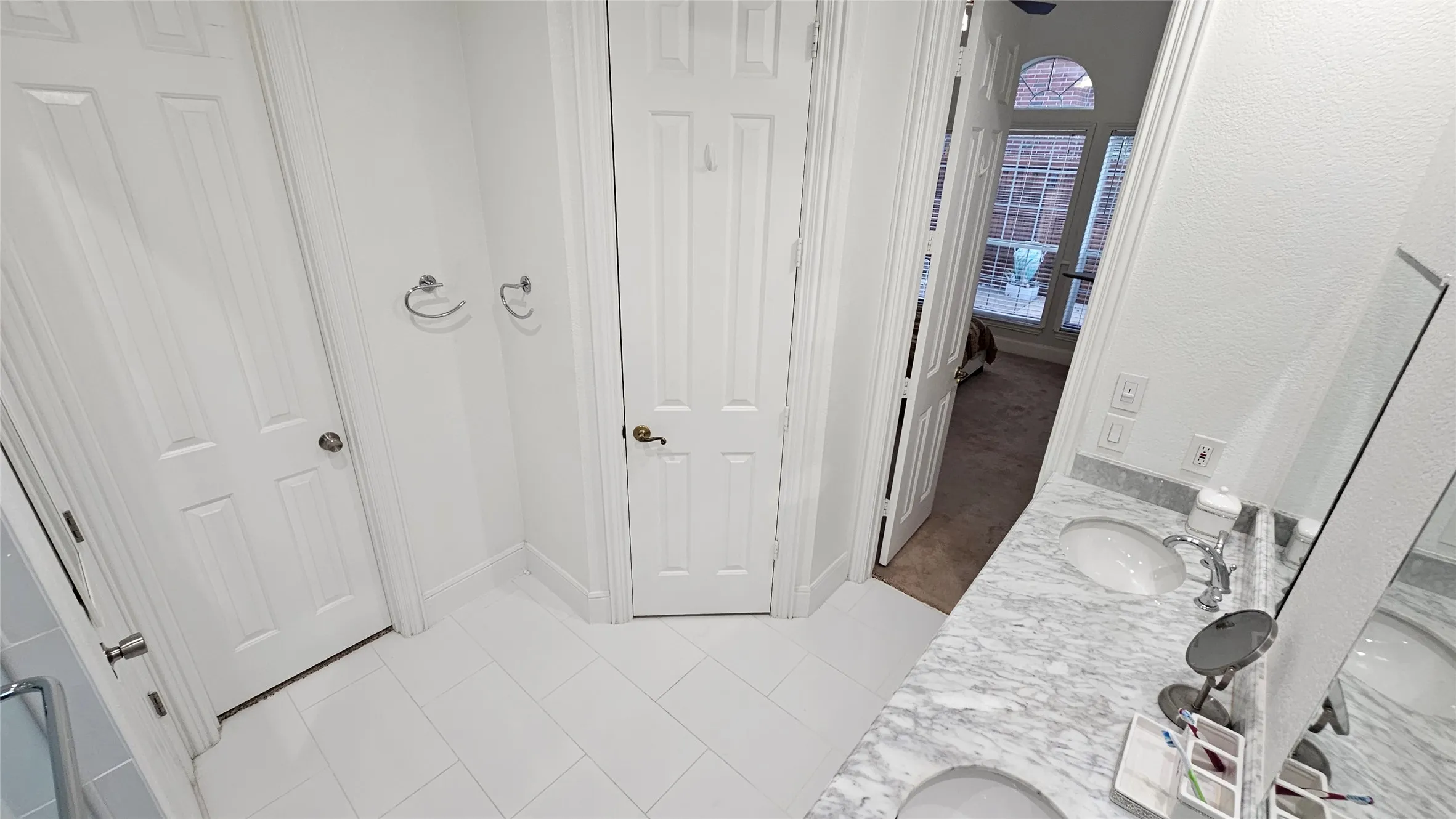 Bathroom featuring a double vanity with stone countertops, undermount sinks, and chrome fixtures