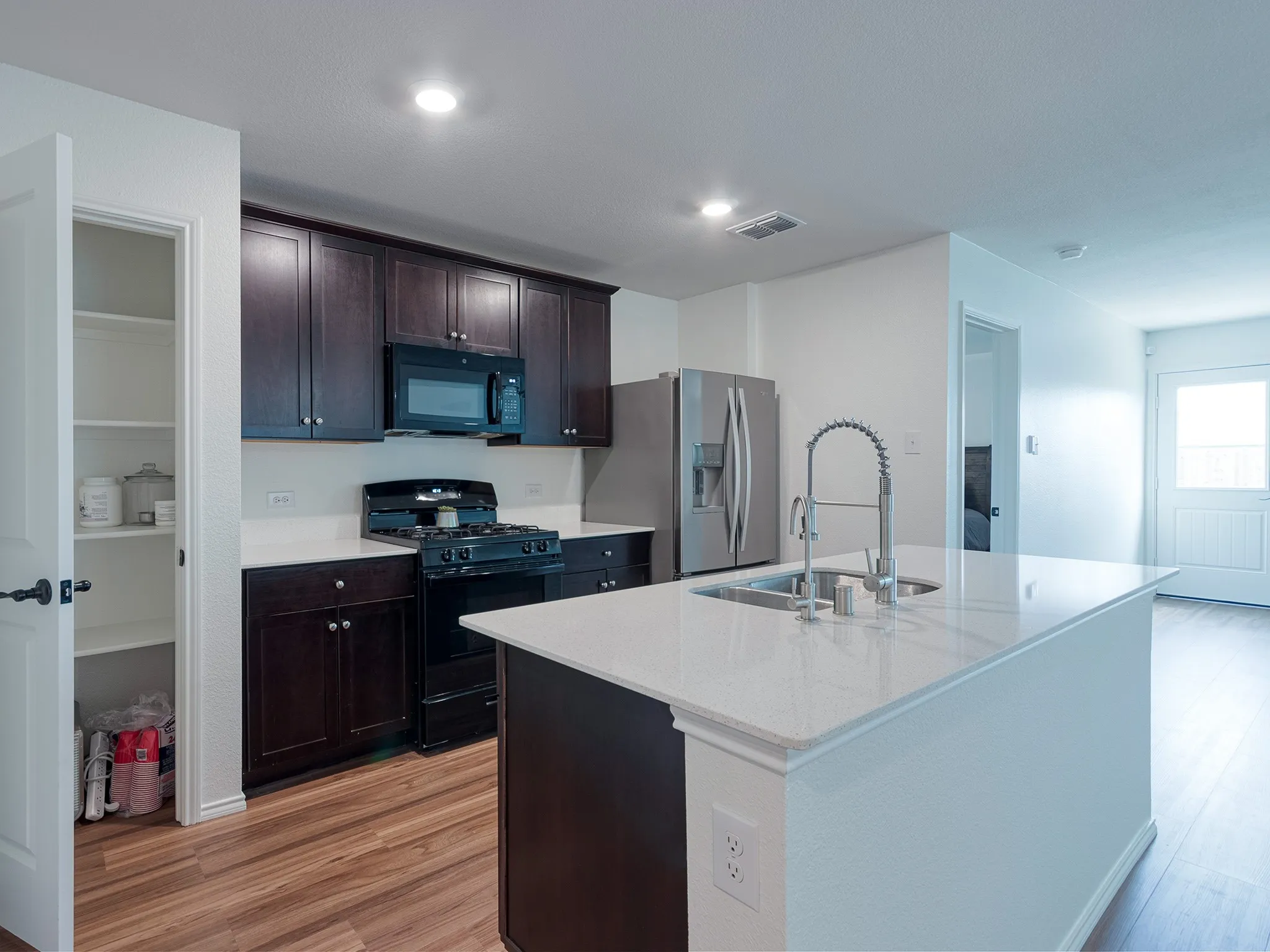 Open kitchen with stove, microwave and reverse osmosis water system.