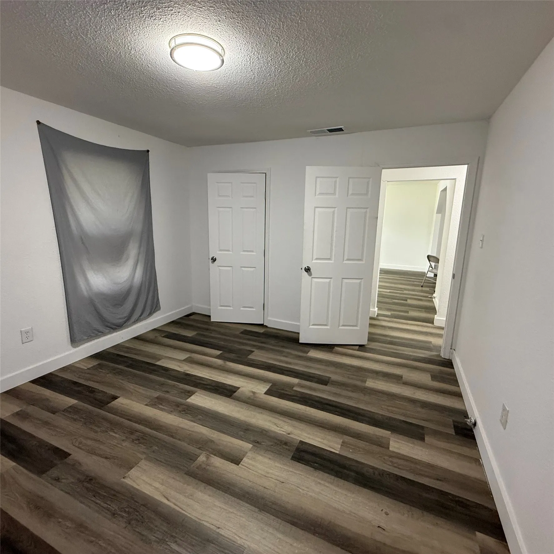 Interior room featuring wood-finish flooring, white painted walls, and white trim