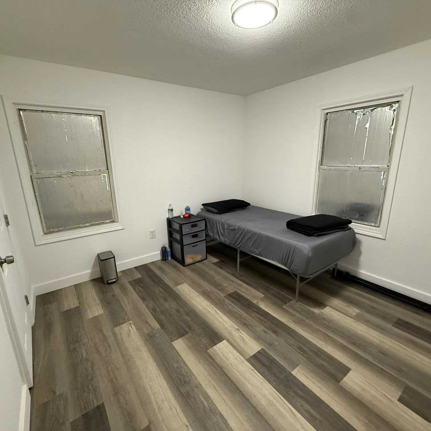 Room featuring light-toned wood-finish flooring and bright white walls
