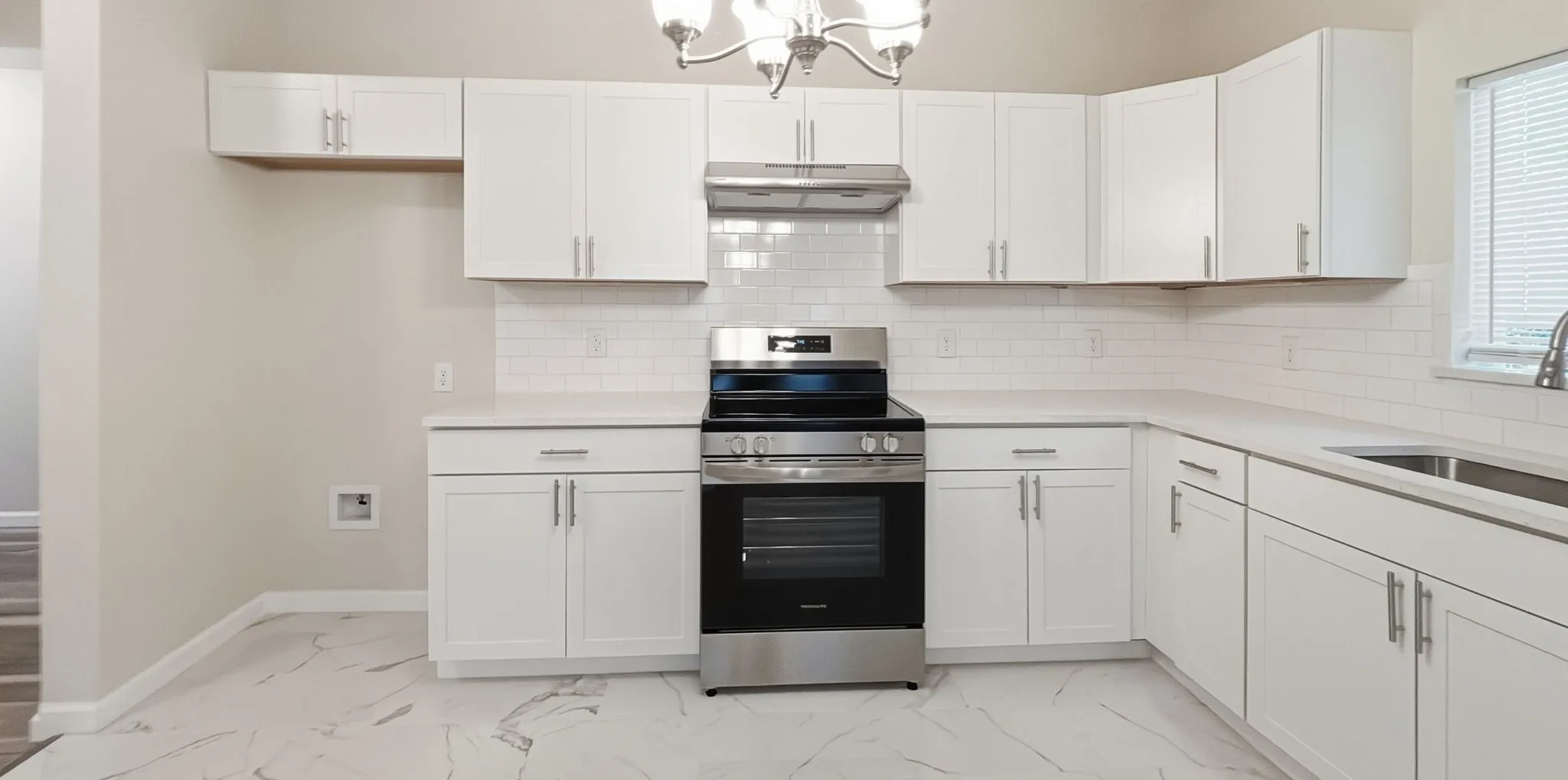 Modern kitchen with white cabinetry and light countertops