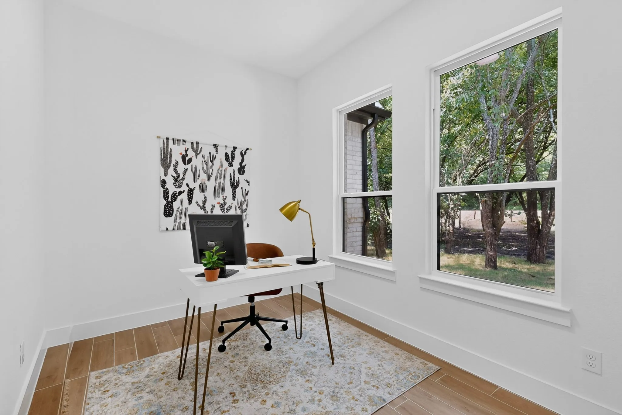 Bright room with wood-finish flooring and multiple windows, providing ample natural light