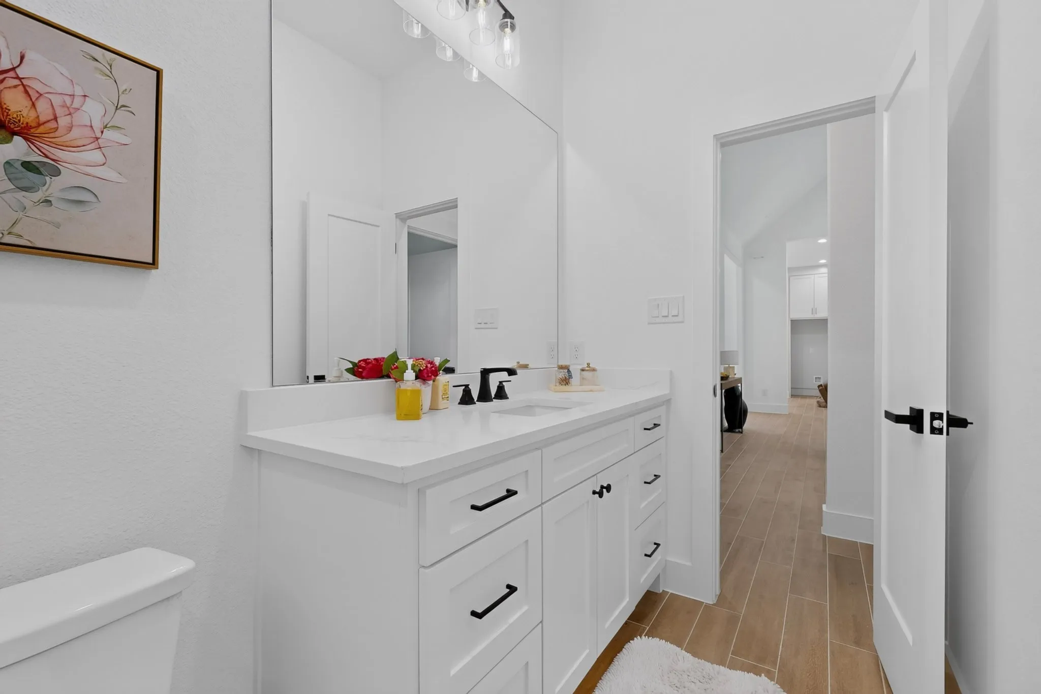 Bathroom vanity featuring a white countertop, undermount sink, and black faucet