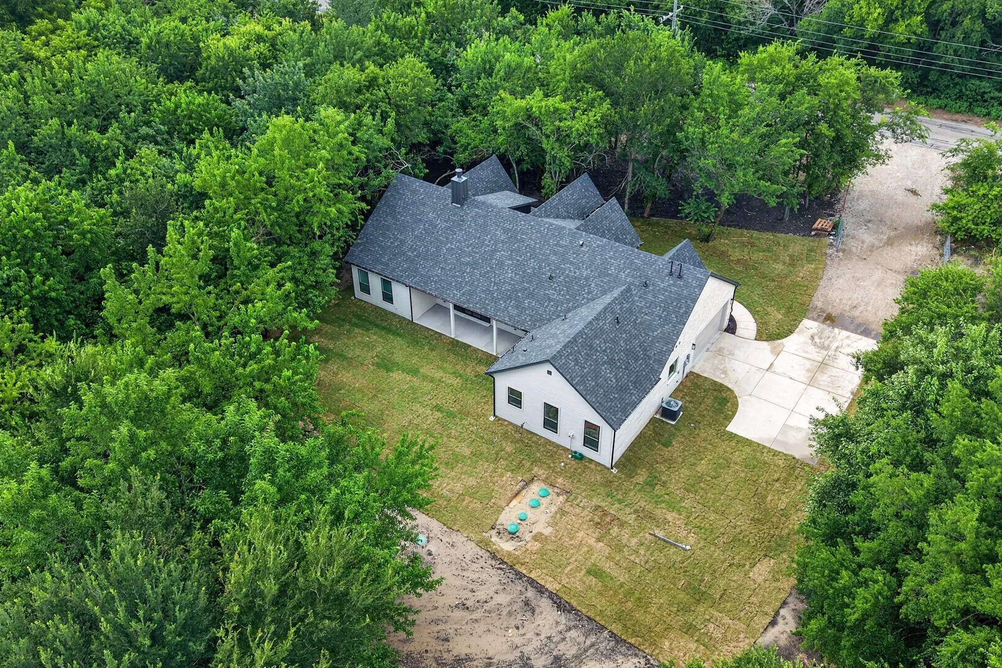 Contemporary residence featuring a dark shingle roof and light-colored siding