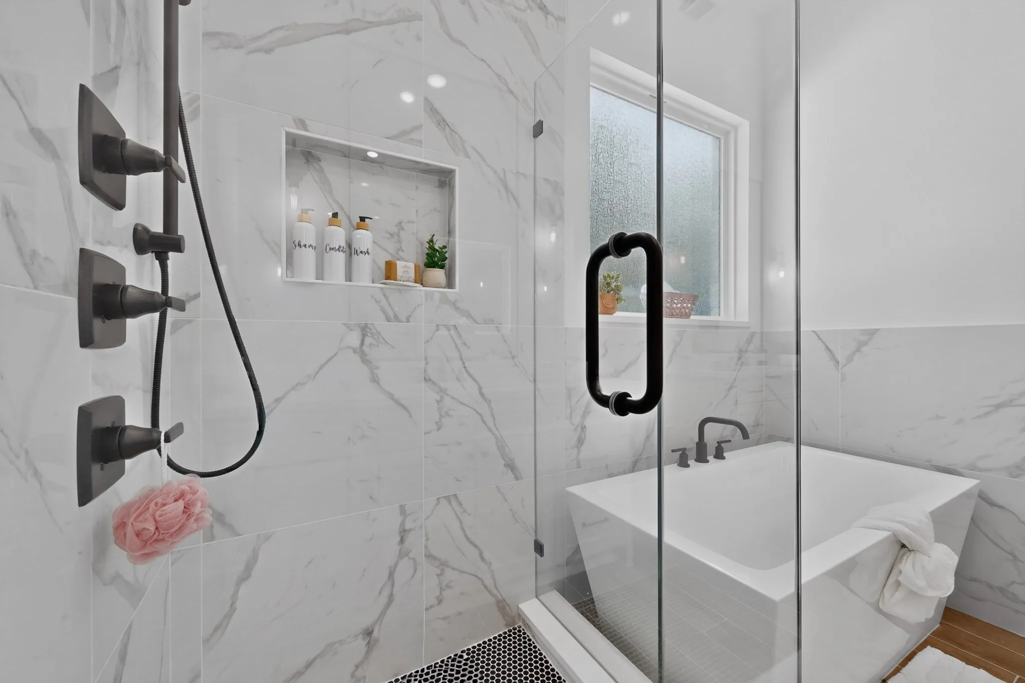 Contemporary bathroom featuring a frameless glass shower enclosure, a built-in shower niche with recessed lighting, and a square soaking tub