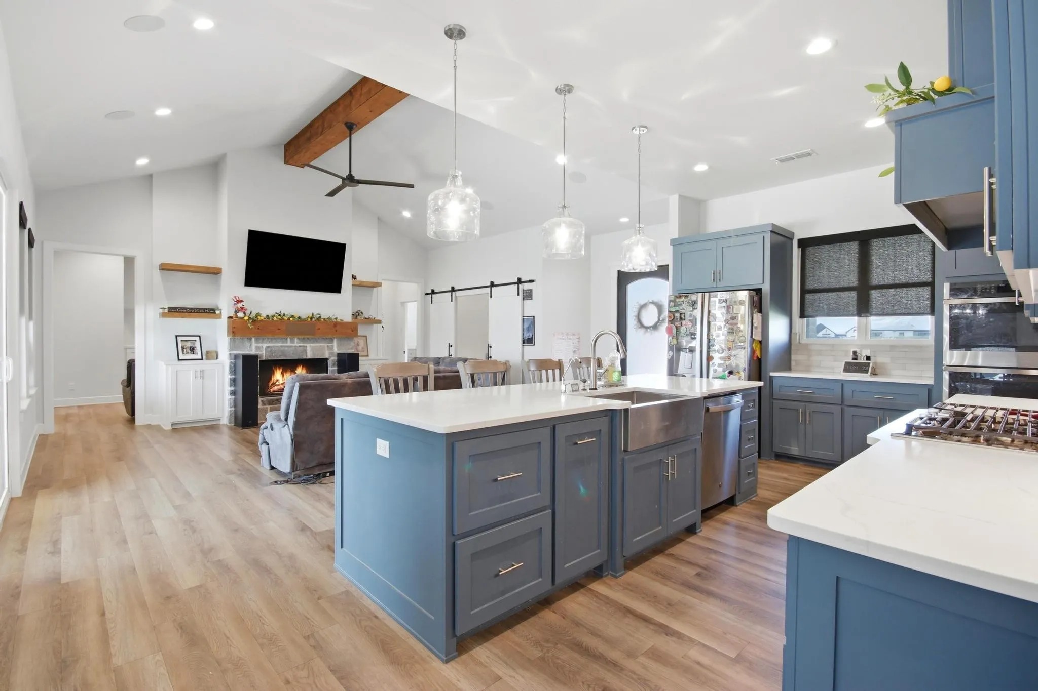 Modern kitchen featuring blue cabinetry, white countertops, a large island with an undermount sink, and stainless steel appliances