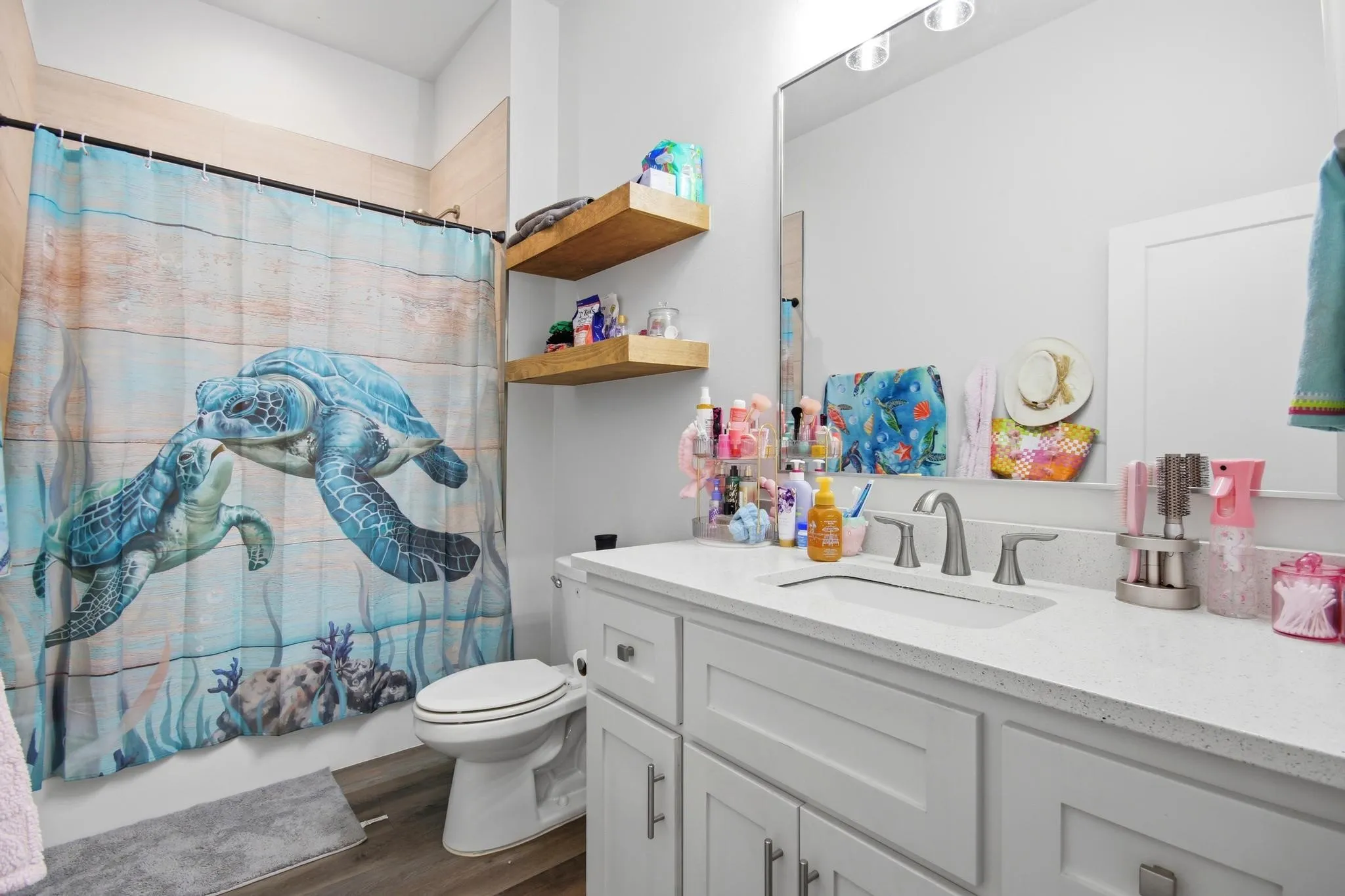 Bathroom featuring a single vanity with light grey cabinetry, a light-colored countertop, and a rectangular undermount sink