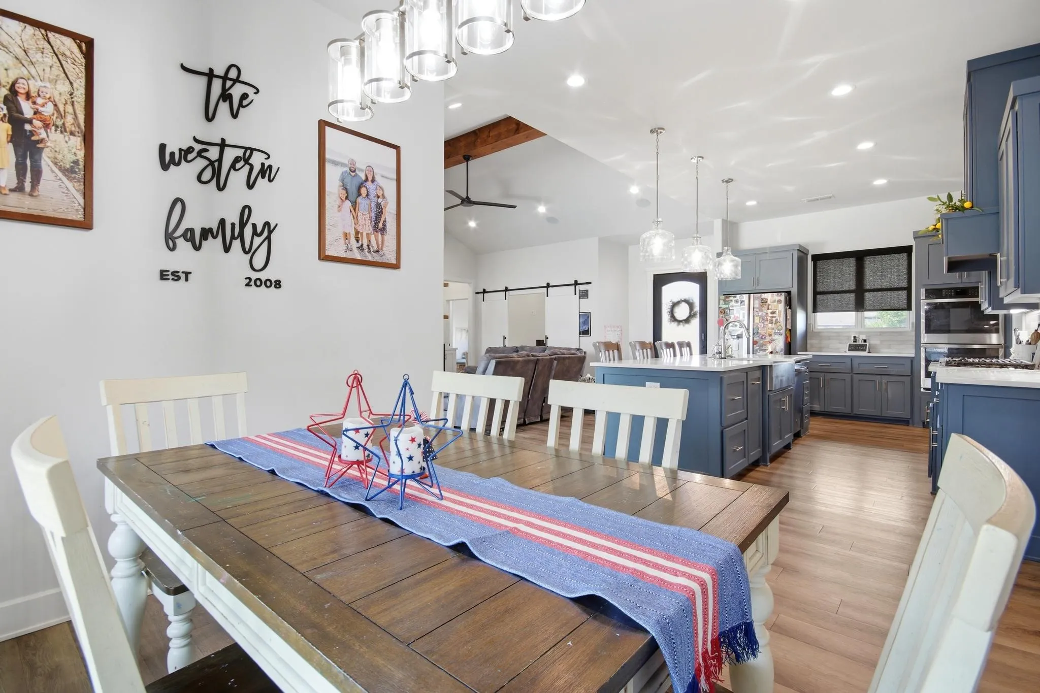 Open-concept dining area with wood-finish flooring, recessed lighting, and a linear chandelier