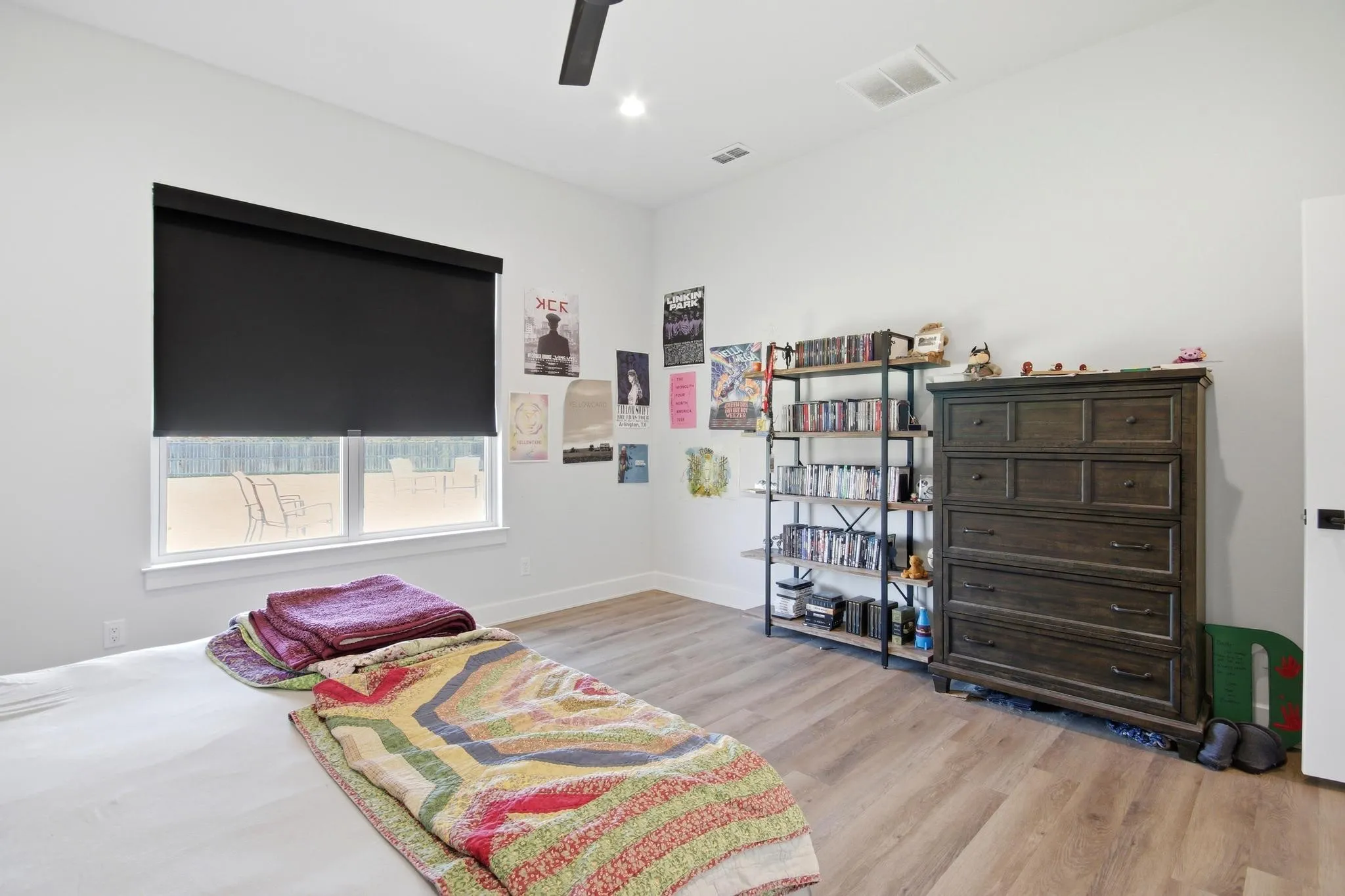 Bright room featuring a large window with privacy shade, wood-finish flooring, recessed lighting, and a ceiling fan