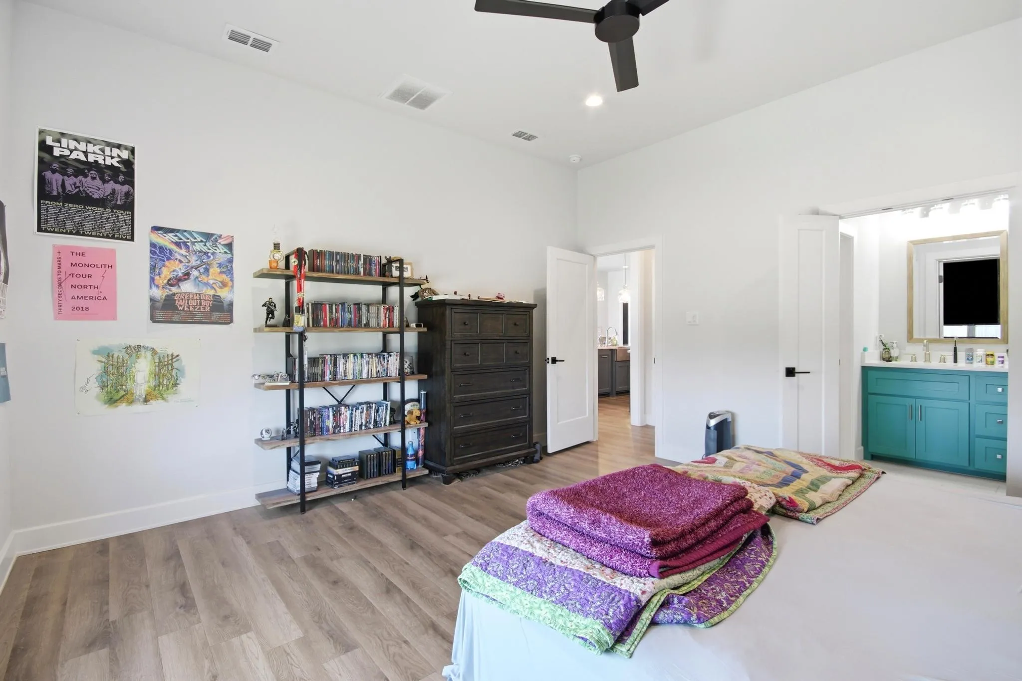 Spacious room featuring wood-finish flooring, a contemporary ceiling fan, and recessed lighting