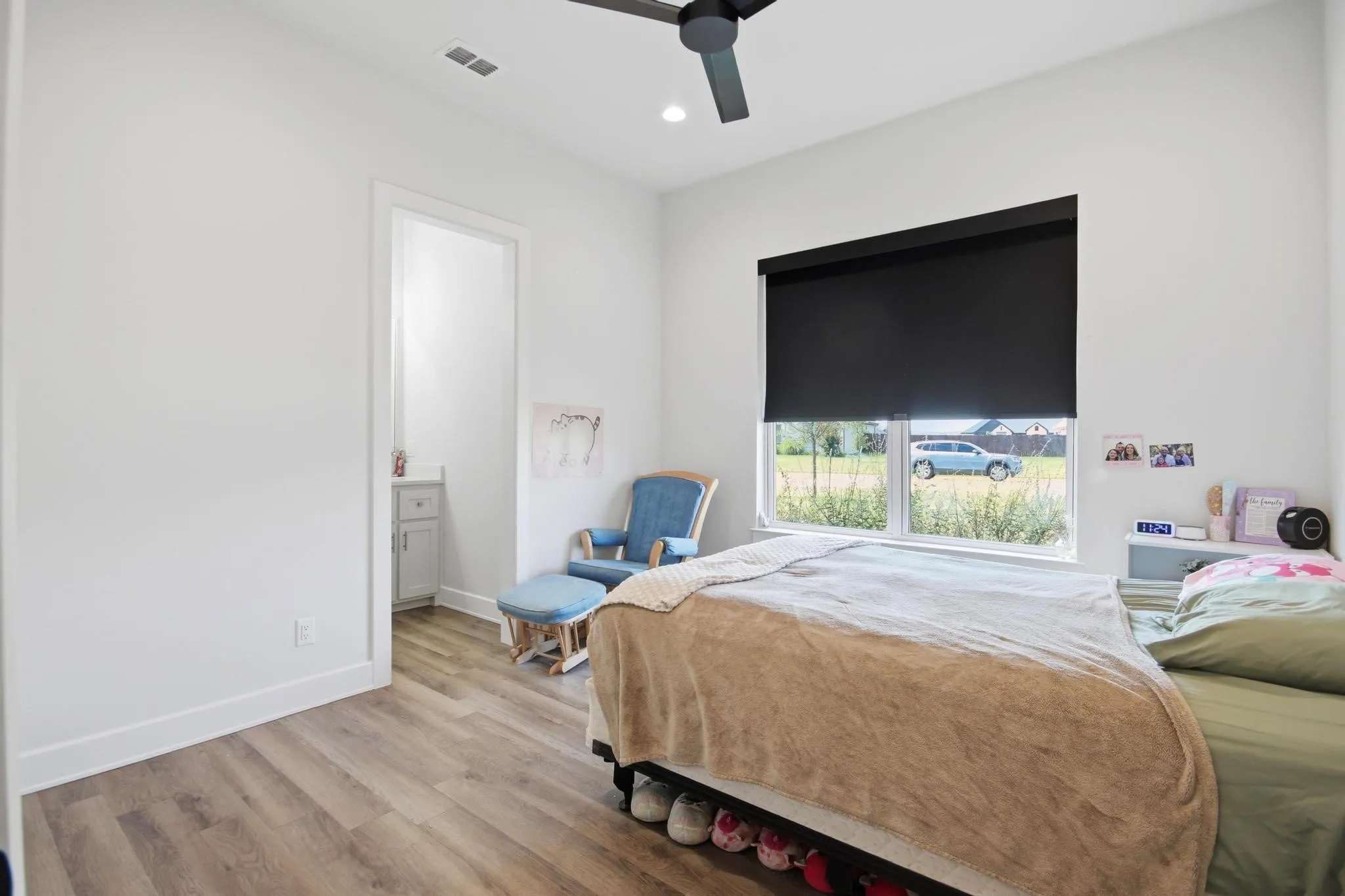 Room featuring wood-finish flooring, a white trim package, and a ceiling fan with integrated lighting