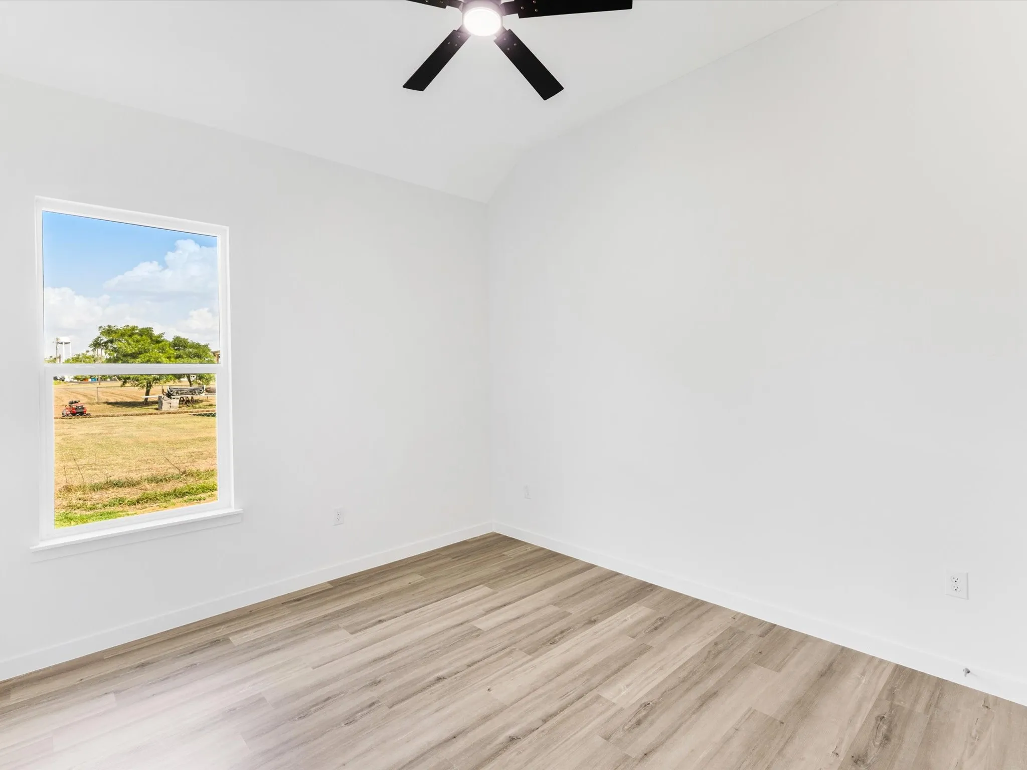 Vaulted ceiling with a black ceiling fan