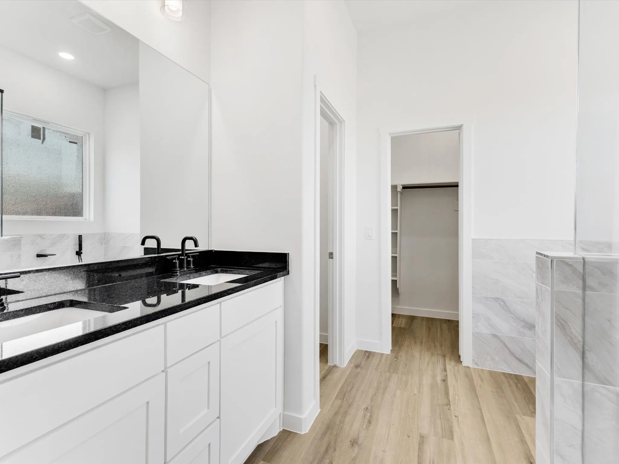 Double vanity with black countertop and undermount sinks