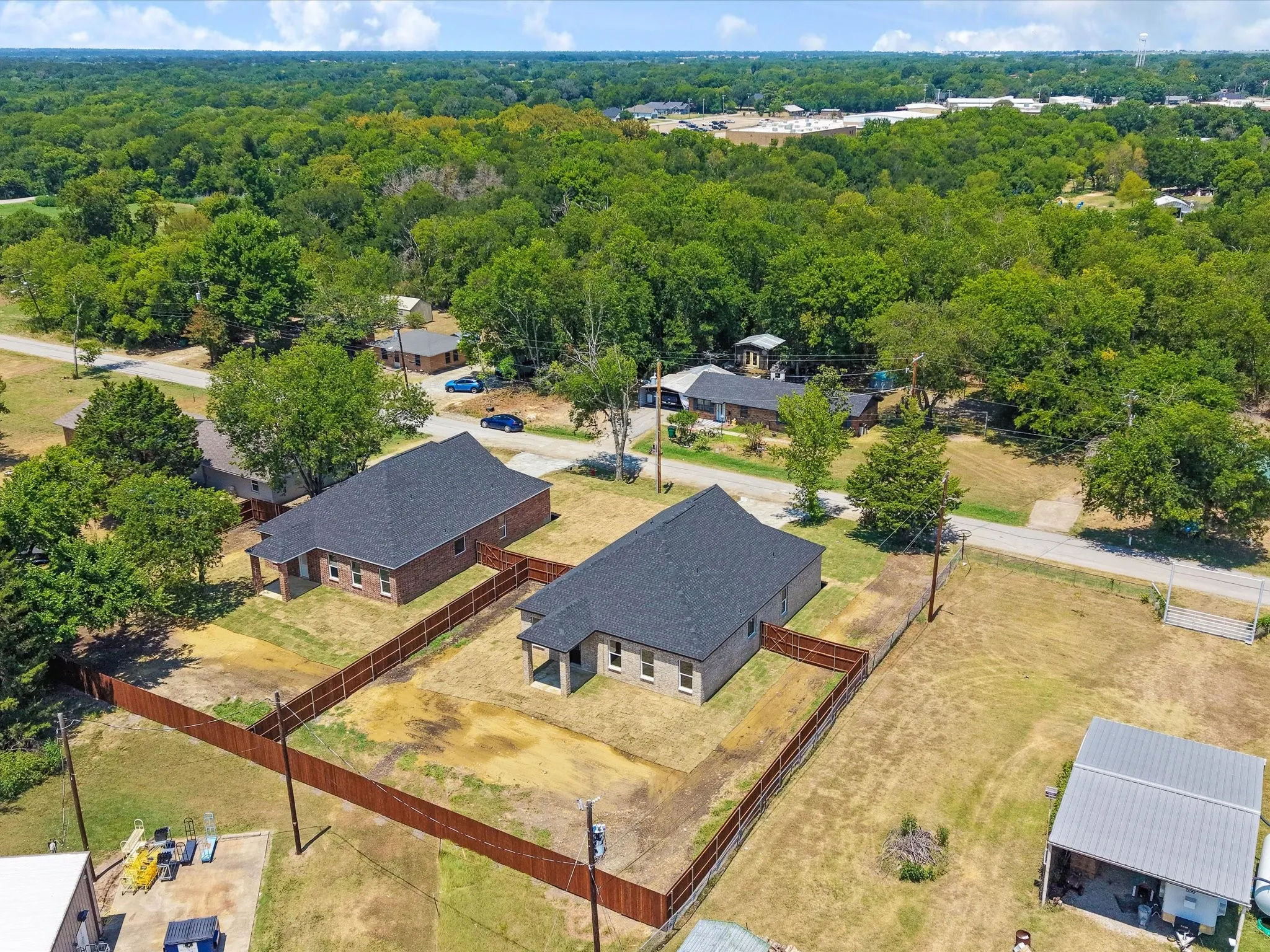 Two properties featuring brick exteriors, dark shingle roofs, and private fencing