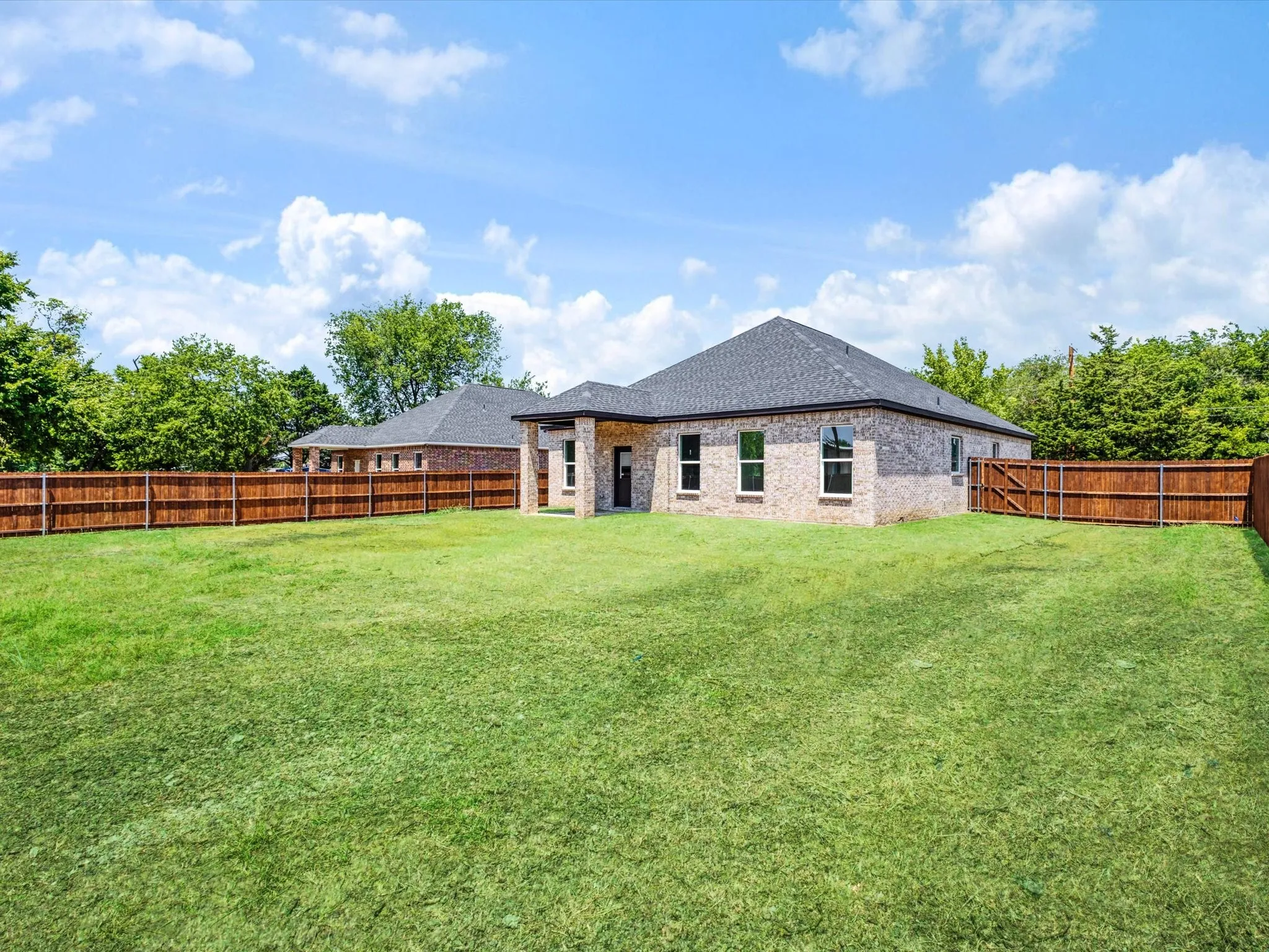 Expansive grassy yard with wood fencing