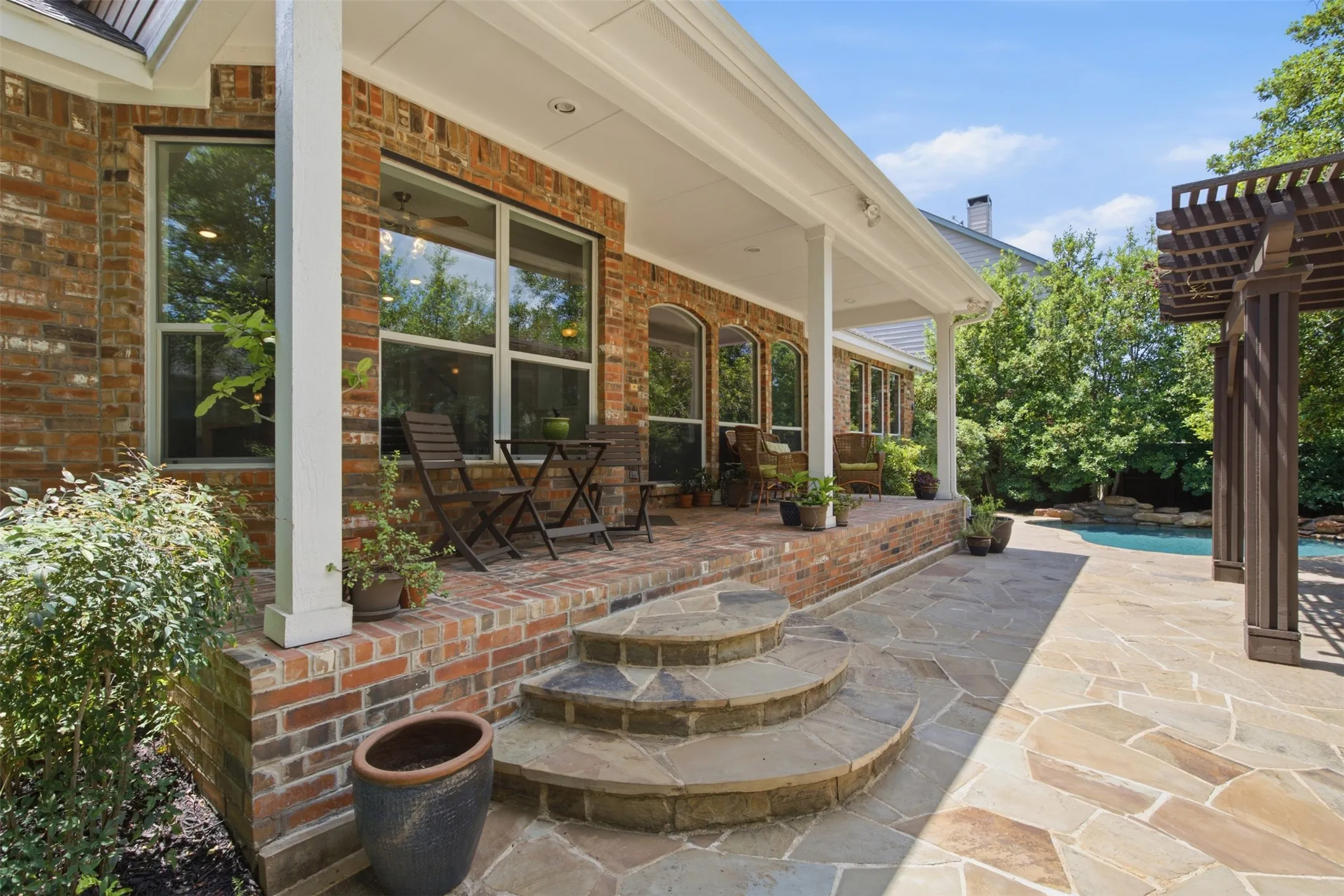 Freeform swimming pool with a rock waterfall feature, integrated tanning ledge, and concrete decking