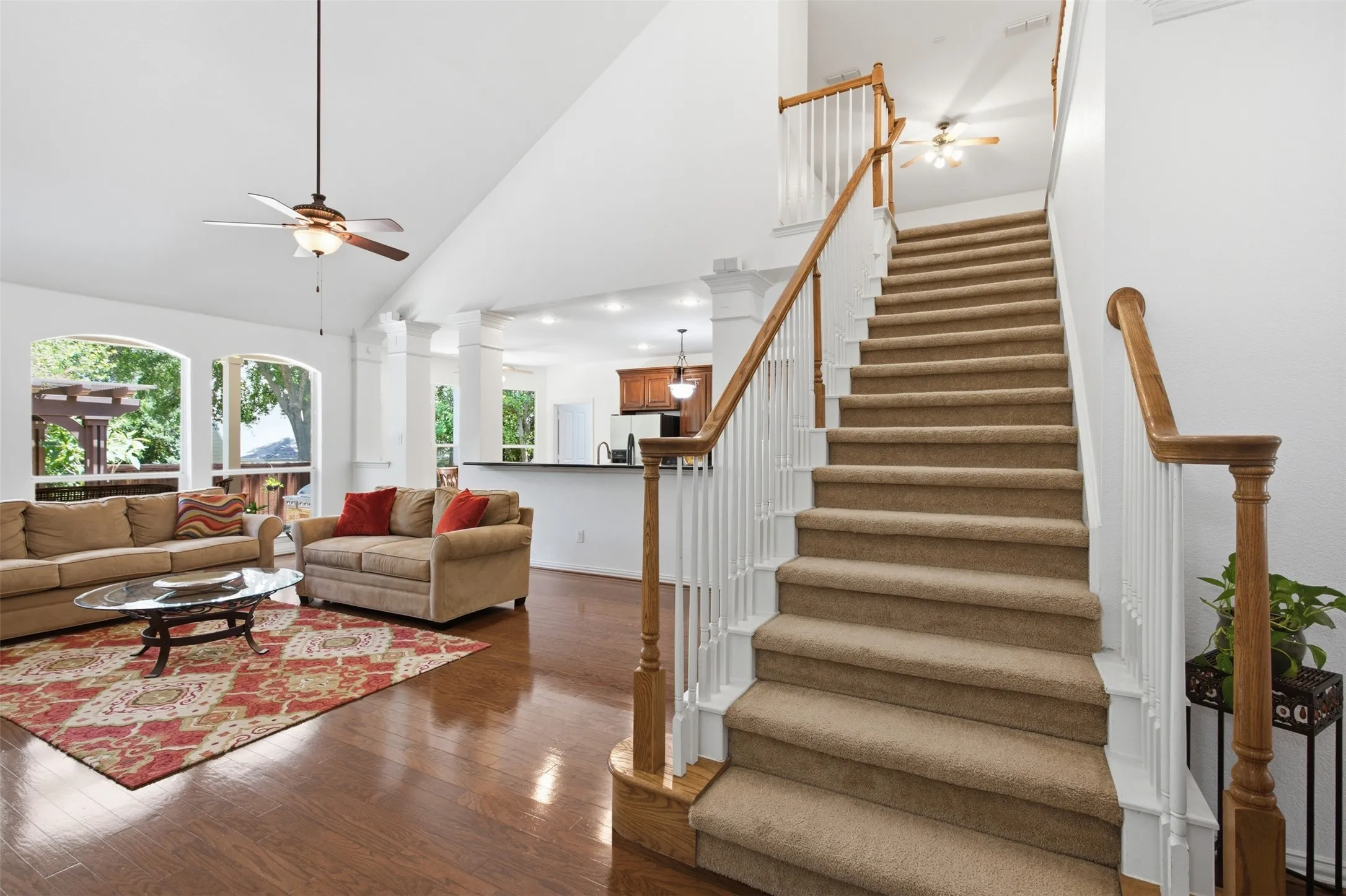 Living area with wood-finish flooring, a fireplace with a stone surround and white mantel, and a built-in wood entertainment center