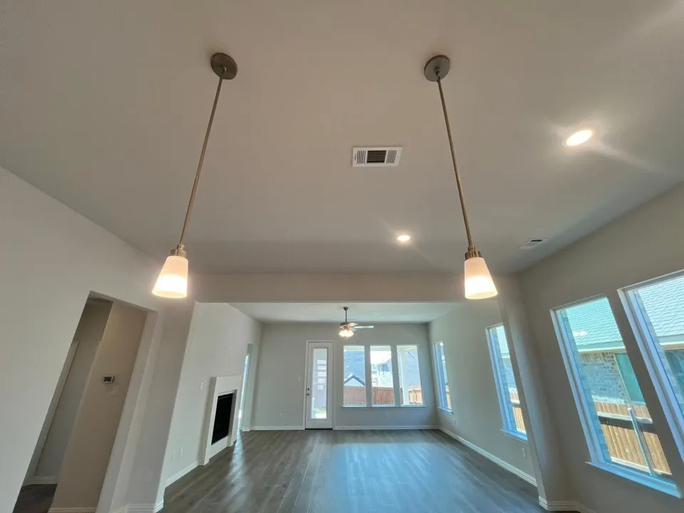 Recessed lighting, pendant lights, wood-finish flooring, multiple windows, and a built-in fireplace