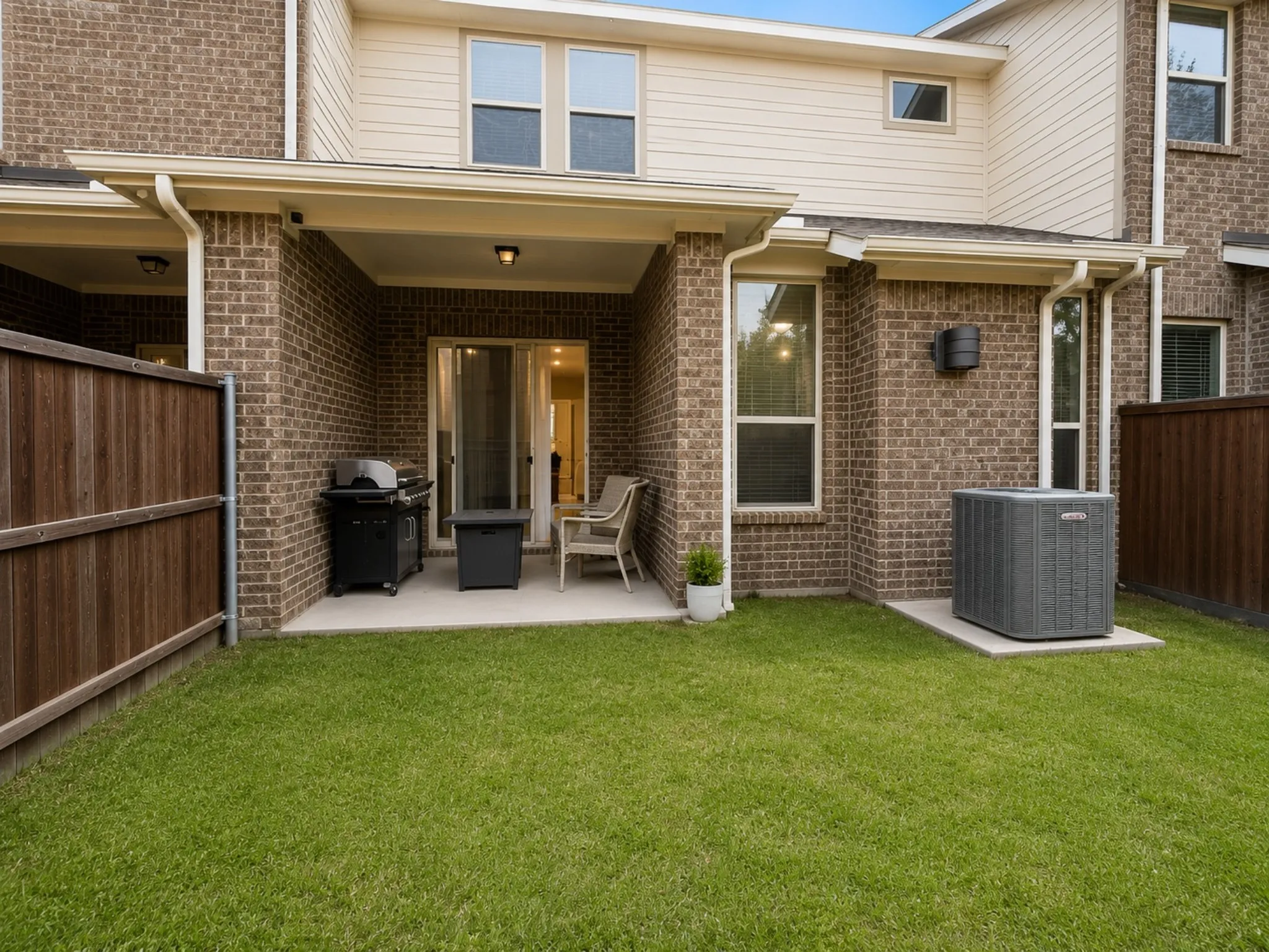 Private fenced yard with a covered patio featuring a concrete slab and overhead lighting