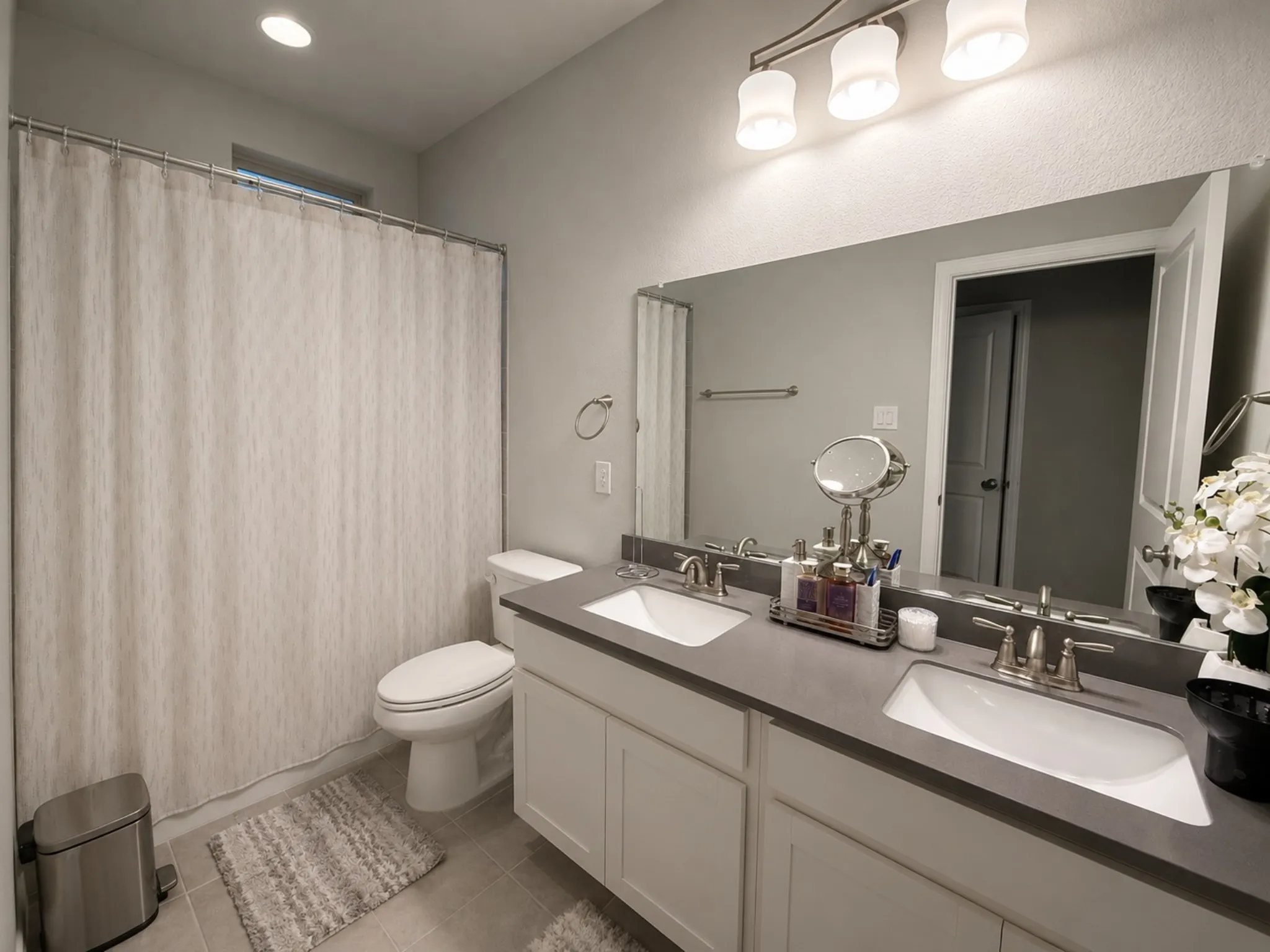 Bathroom featuring a dual vanity with undermount sinks, a long mirror, and a shower/tub combination