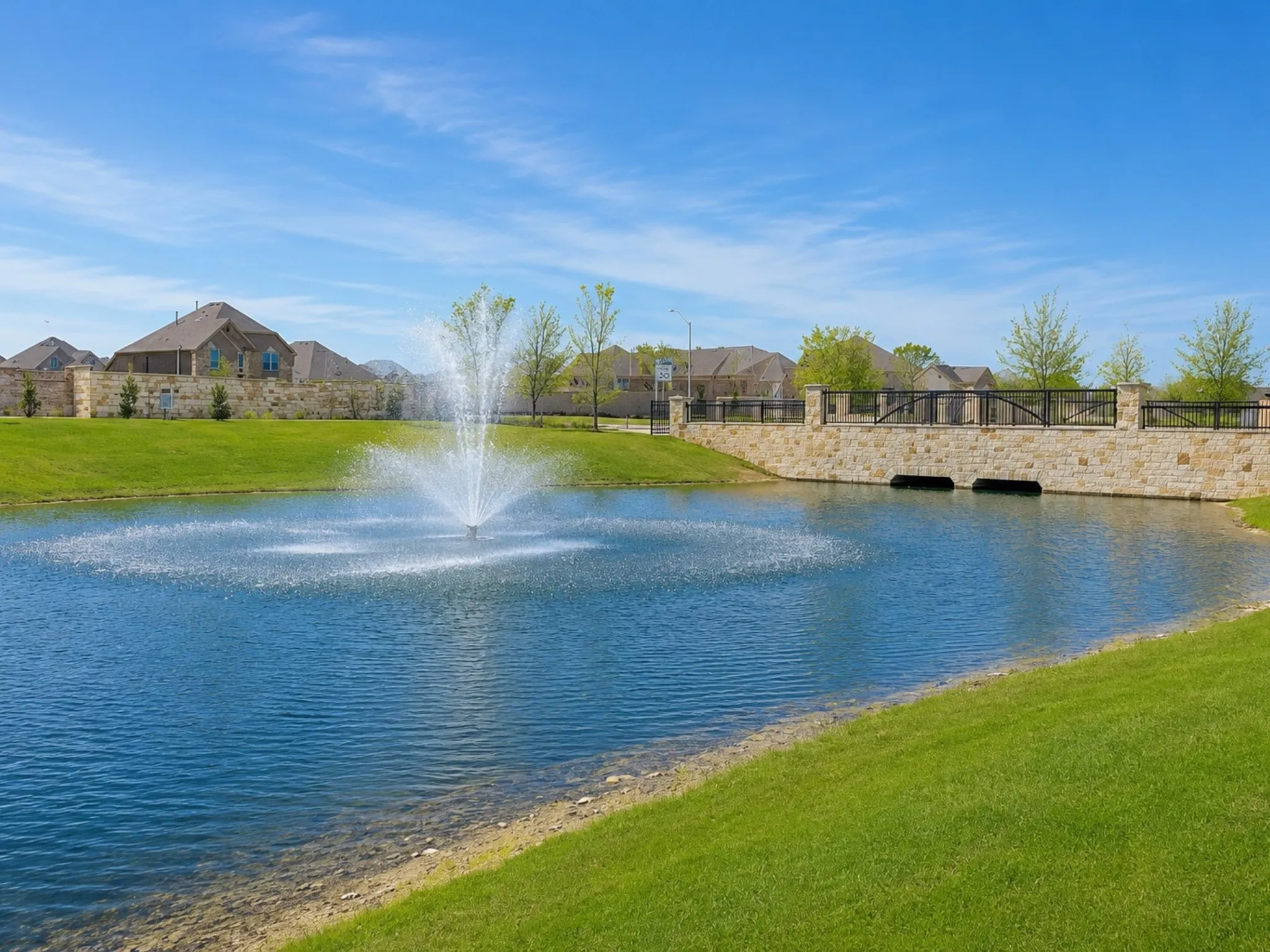 Water feature with an active fountain, surrounded by manicured green spaces