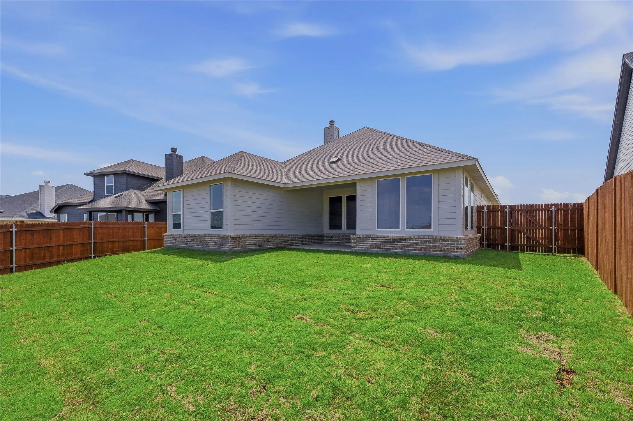 Expansive green lawn with a full wooden fence