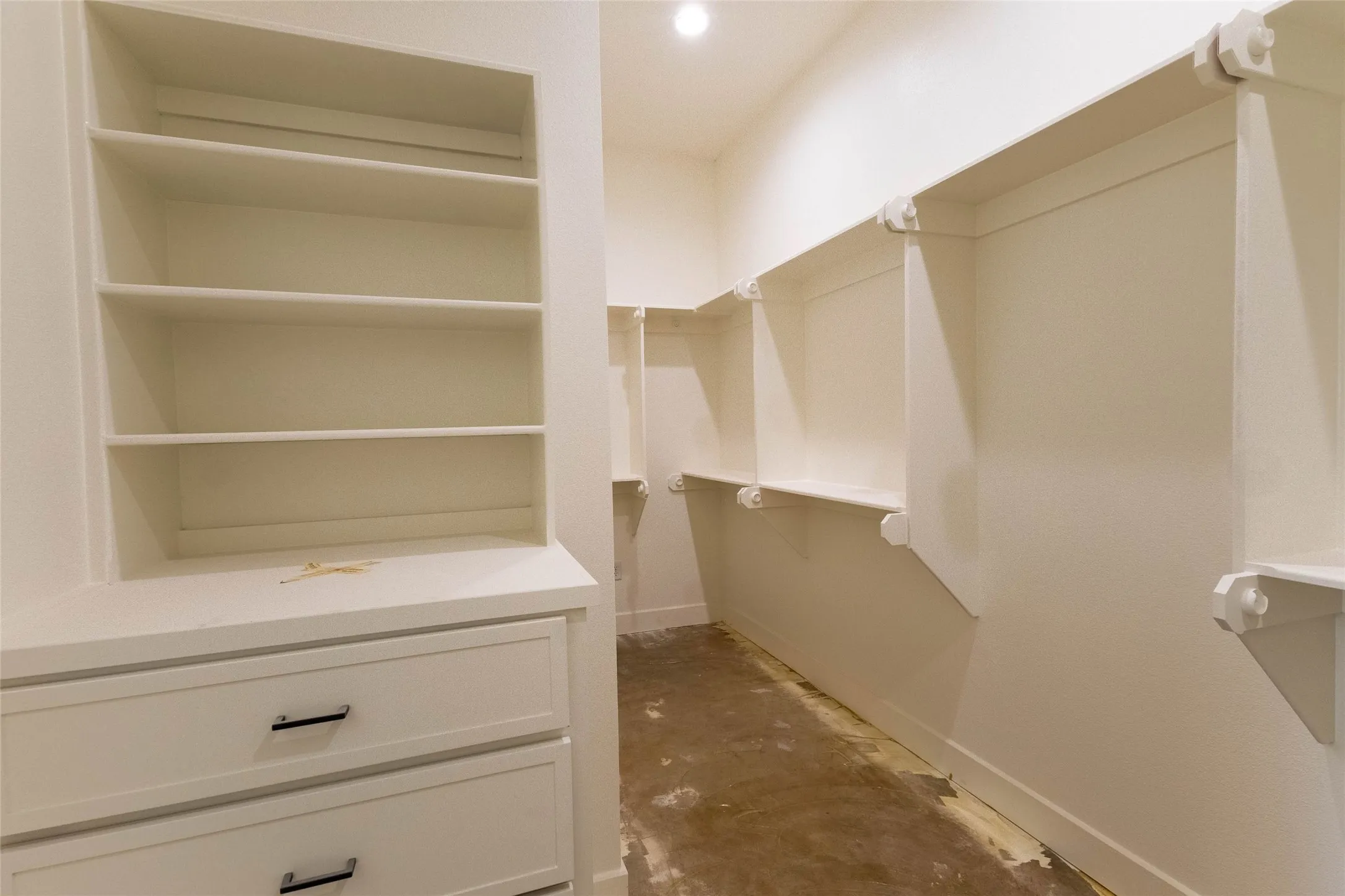 Built-in shelving units, integrated drawers with dark hardware, and recessed lighting