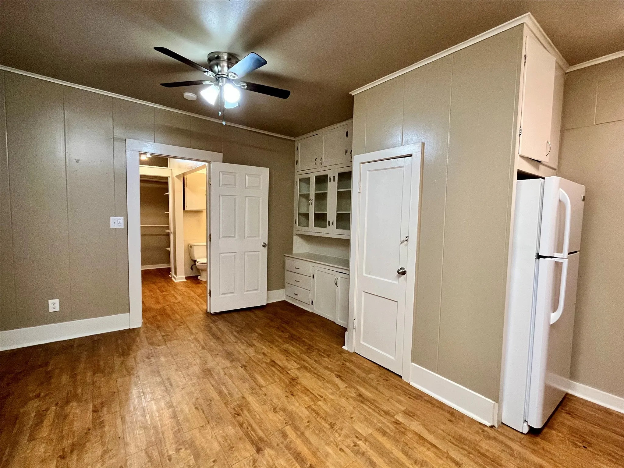With its open-concept layout and breezy ceiling fan, this versatile living space easily accommodates a cozy lounge area.