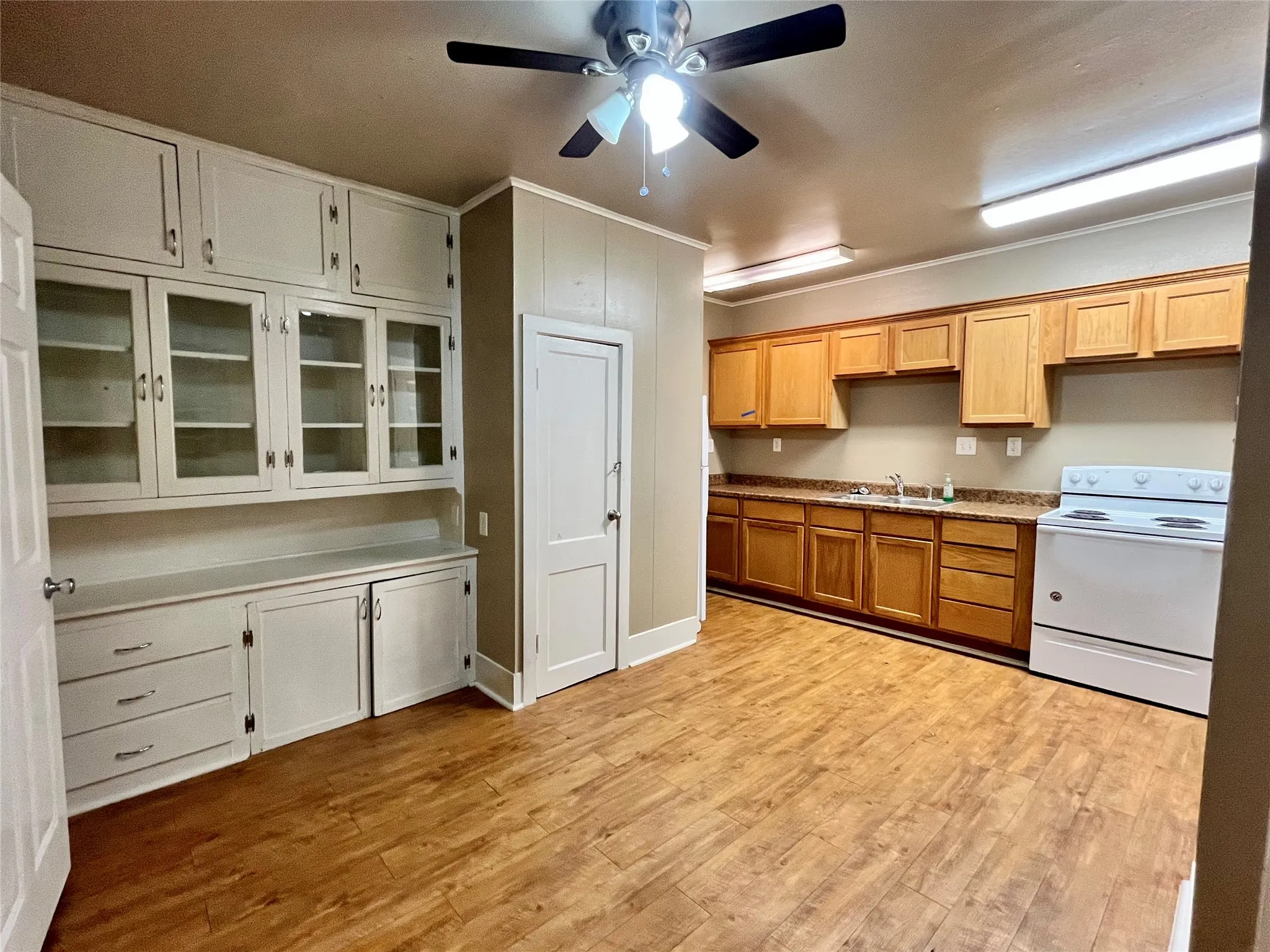 This expansive living area shines with gorgeous wood-style floors and a stunning, built-in vintage hutch with glass doors that adds incredible character and storage.