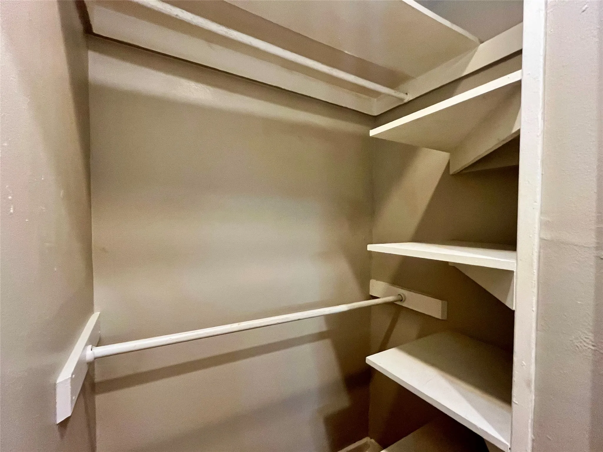Keep your wardrobe perfectly organized with this impressive walk-in closet, complete with sturdy built-in shelving and dual hanging rods.