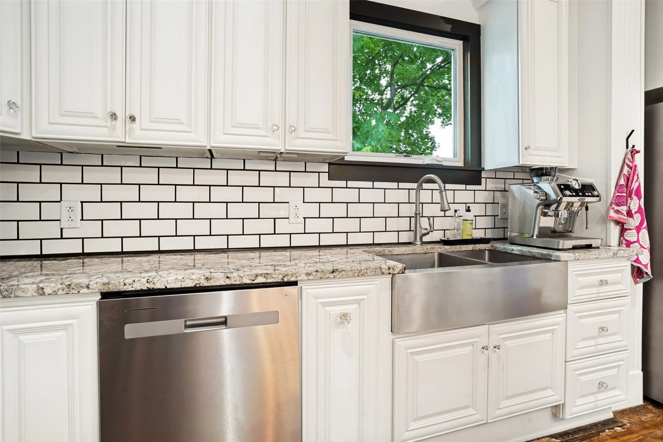 FARM SINK, SHOWCASING THE SUBWAY TILE AND UNDER CABINET LIGHTING